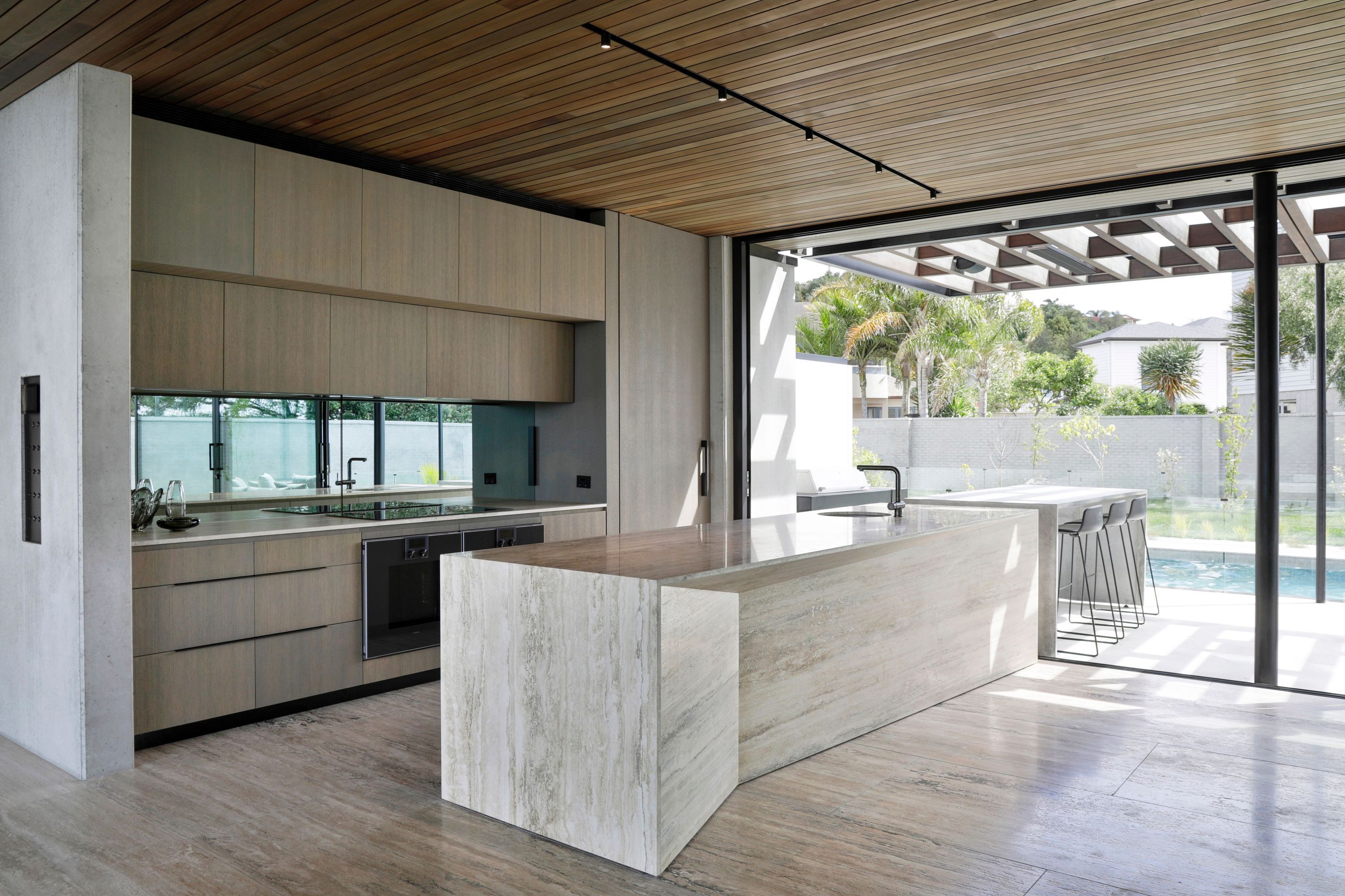 The kitchen island is a sculptural piece, in travertine.