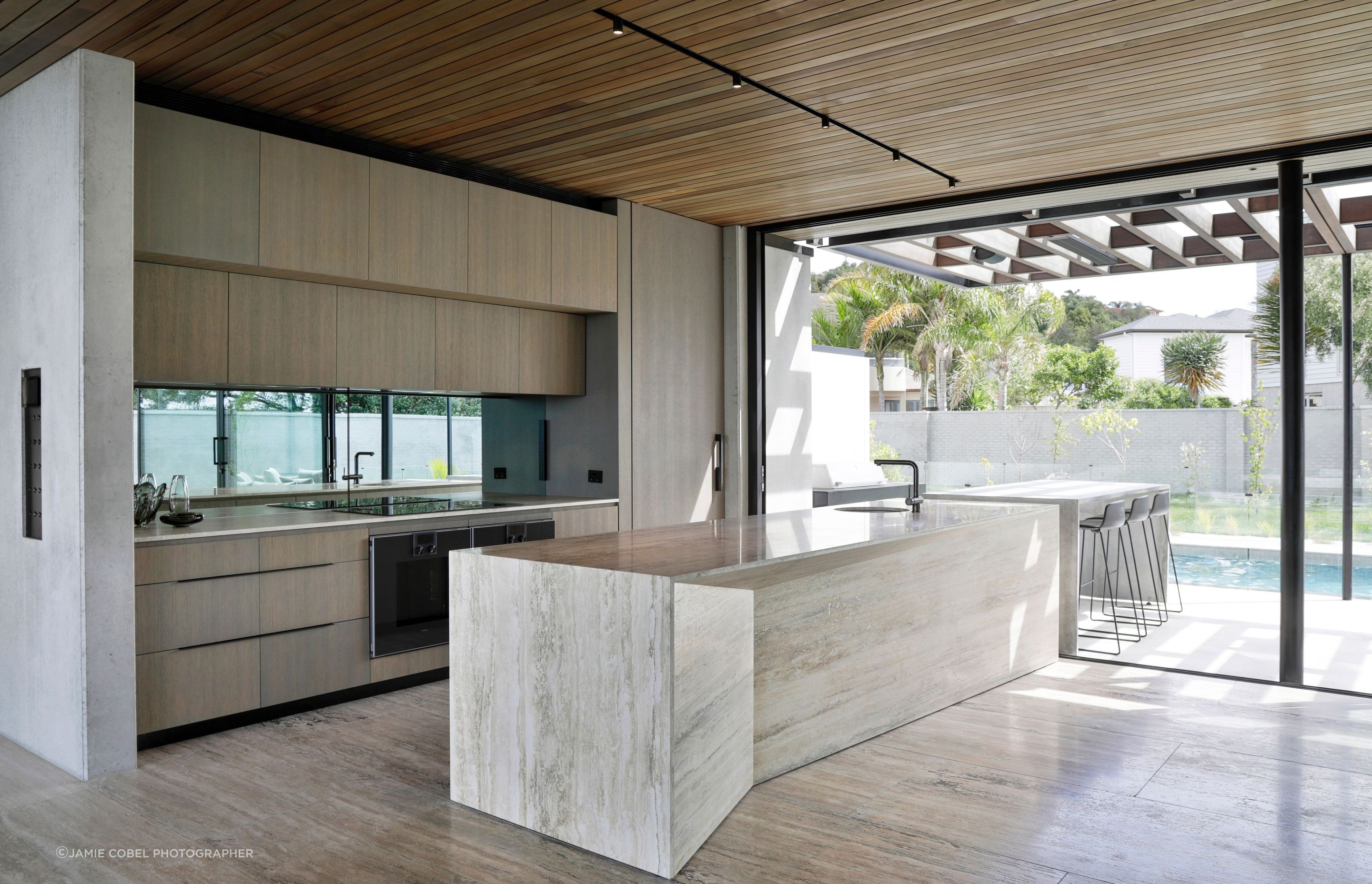 The kitchen island is a sculptural piece, in travertine.