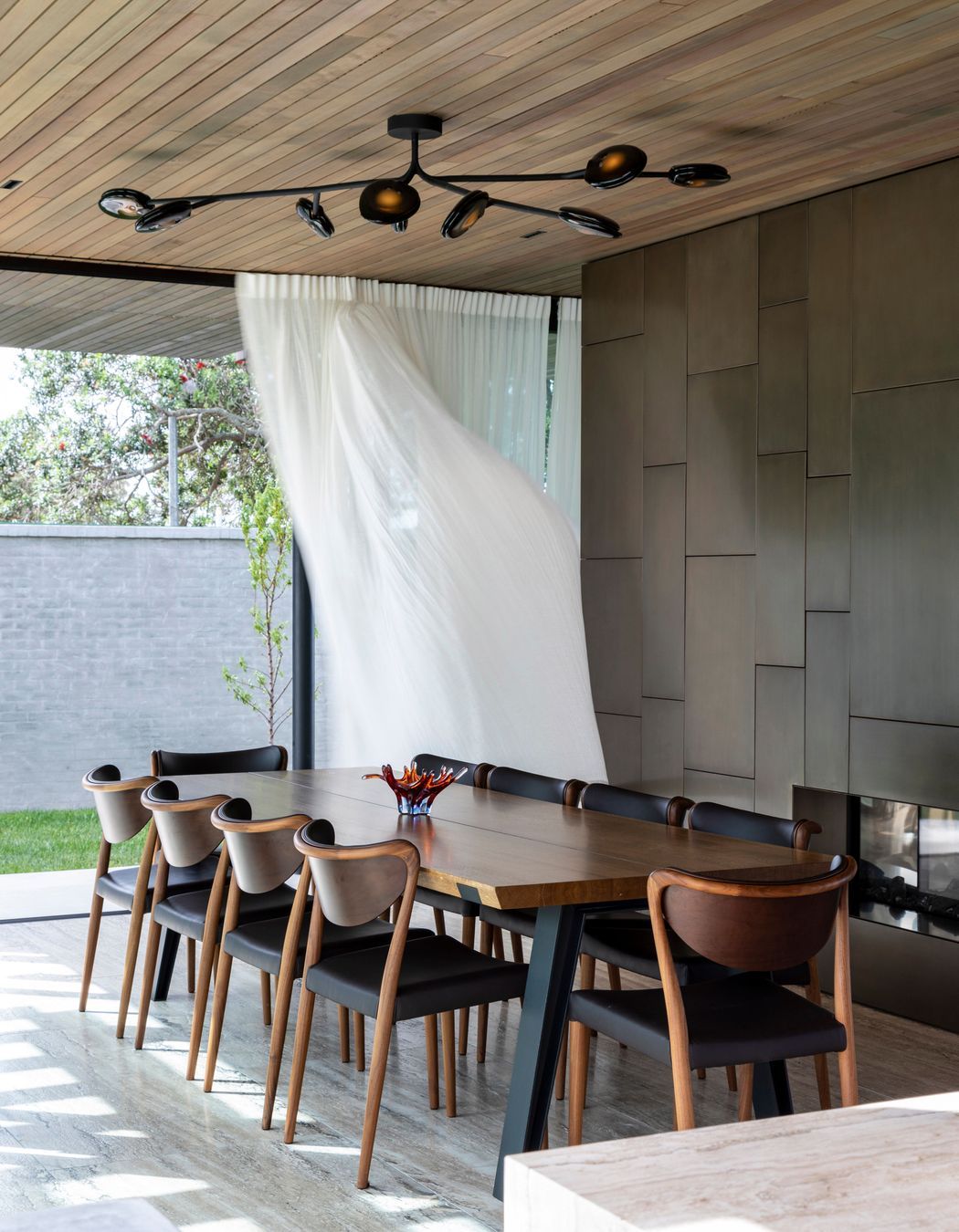 The fireplace delineates the dining and lounging spaces.