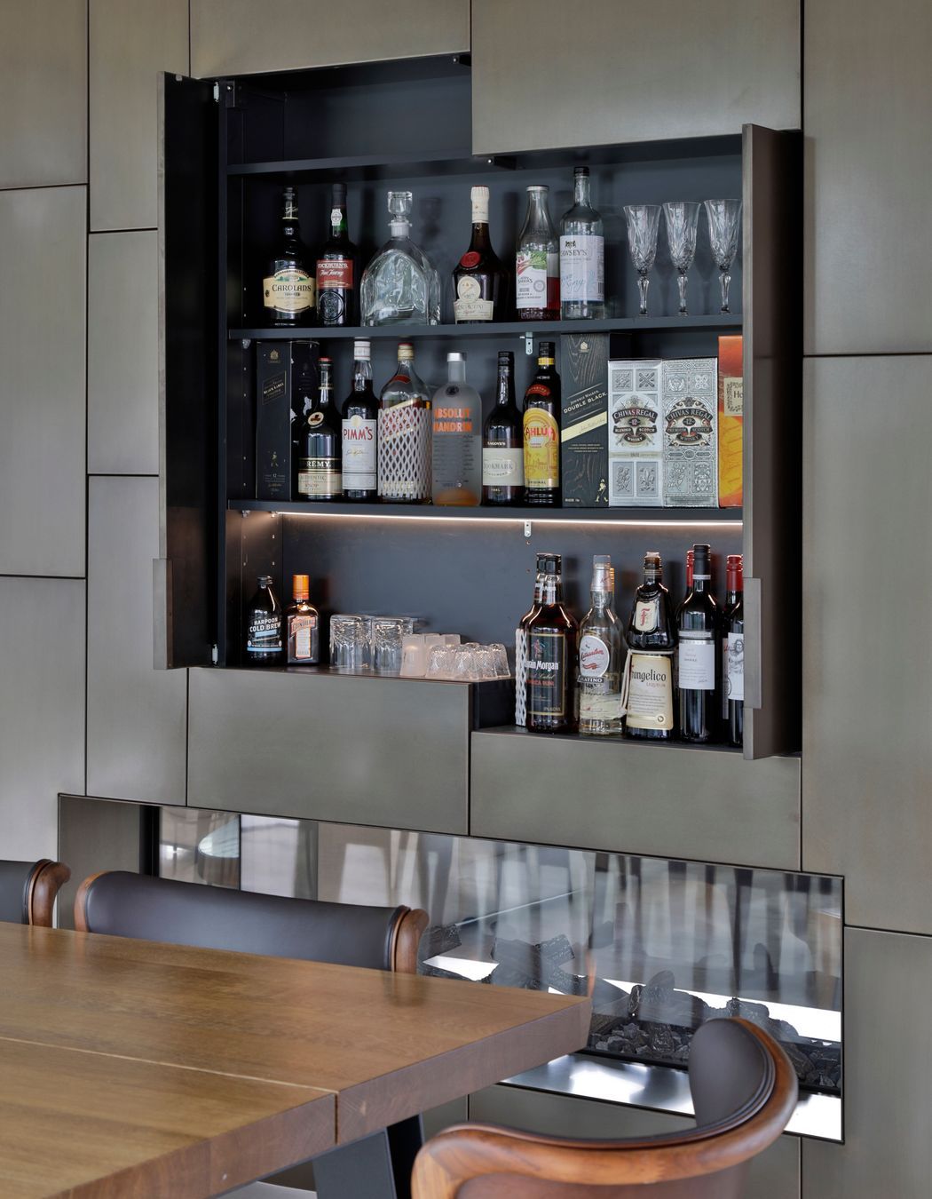 A drinks cabinet is cleverly concealed behind the bronze cladding.