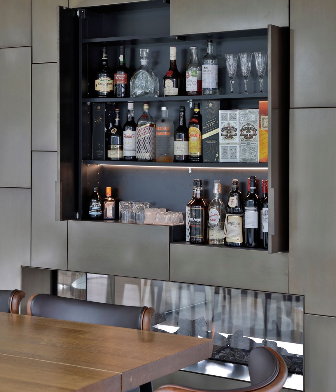 A drinks cabinet is cleverly concealed behind the bronze cladding.