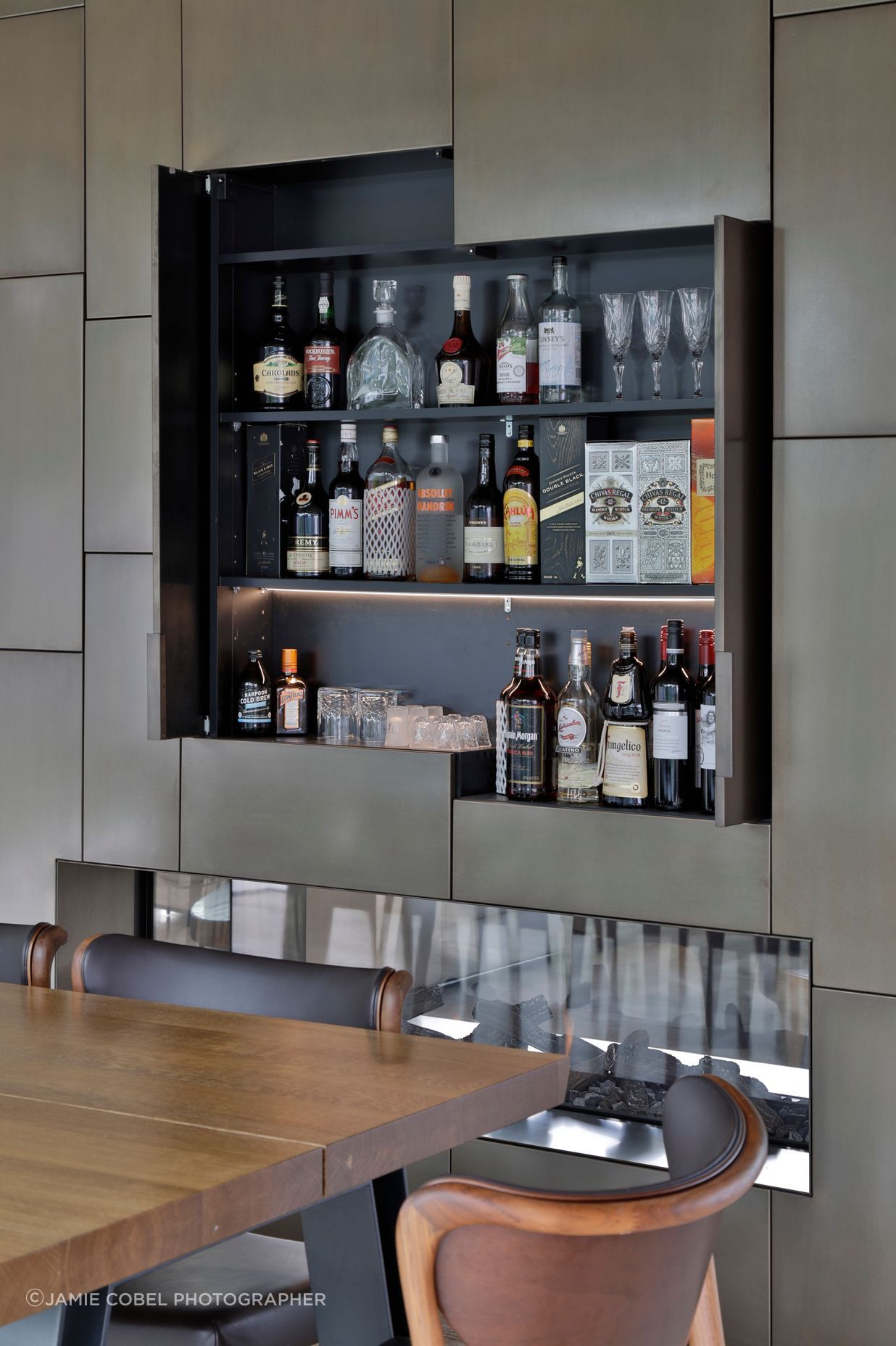 A drinks cabinet is cleverly concealed behind the bronze cladding.