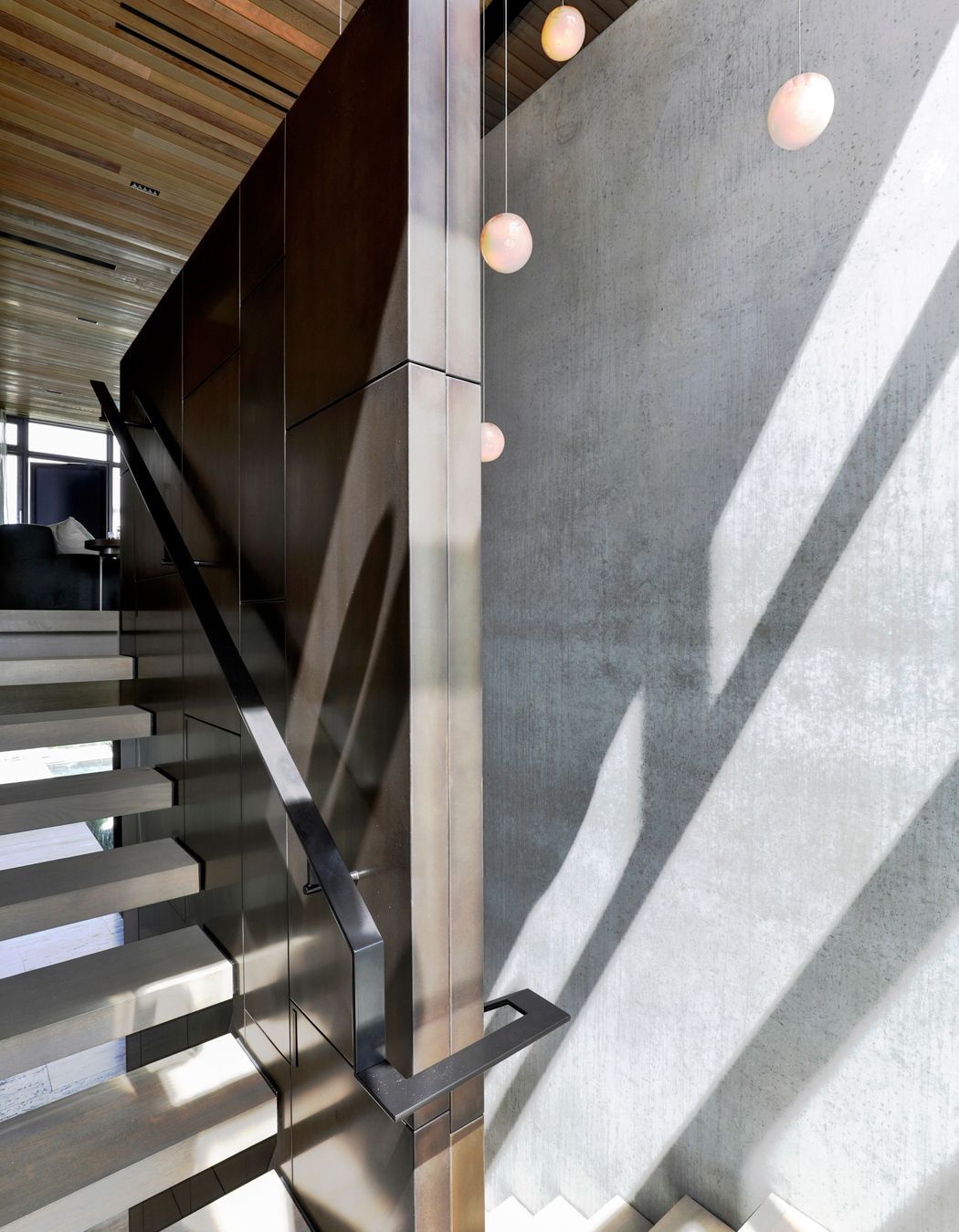 The travertine stairs juxtapose against the bronze wall lining.