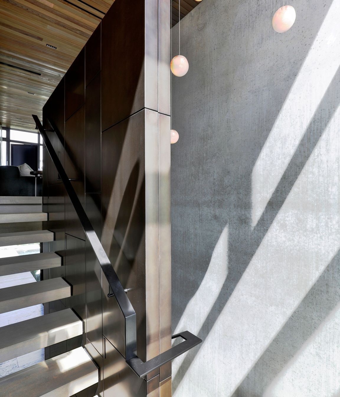The travertine stairs juxtapose against the bronze wall lining.