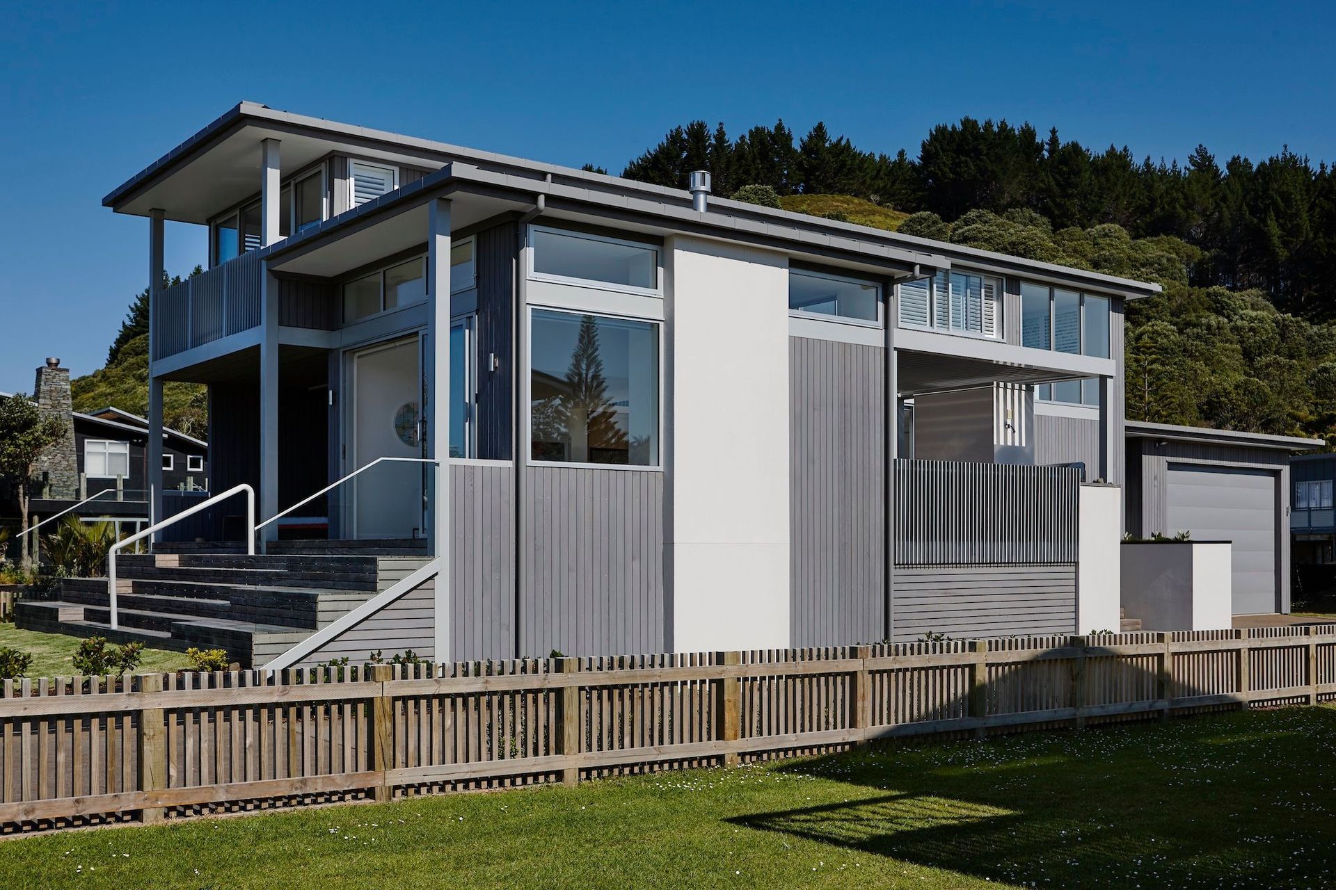 The house is cedar and aluminium, chosen to withstand the coastal environment. “When we were thinking about material palettes it really does speak to the New Zealand vernacular: those greys, those lighter colours, and the backdrop of bush,” says Kate.