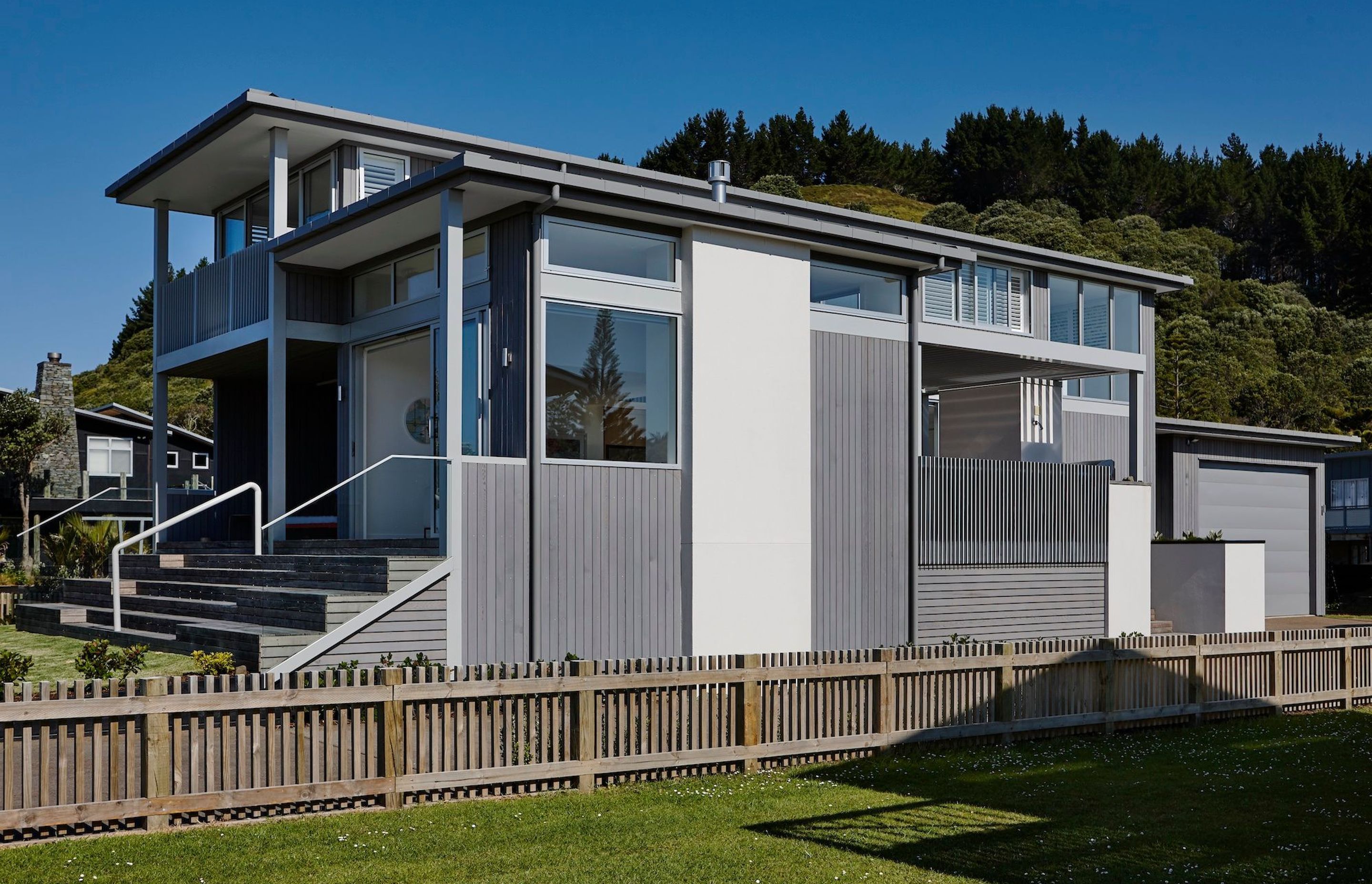 The house is cedar and aluminium, chosen to withstand the coastal environment. “When we were thinking about material palettes it really does speak to the New Zealand vernacular: those greys, those lighter colours, and the backdrop of bush,” says Kate.