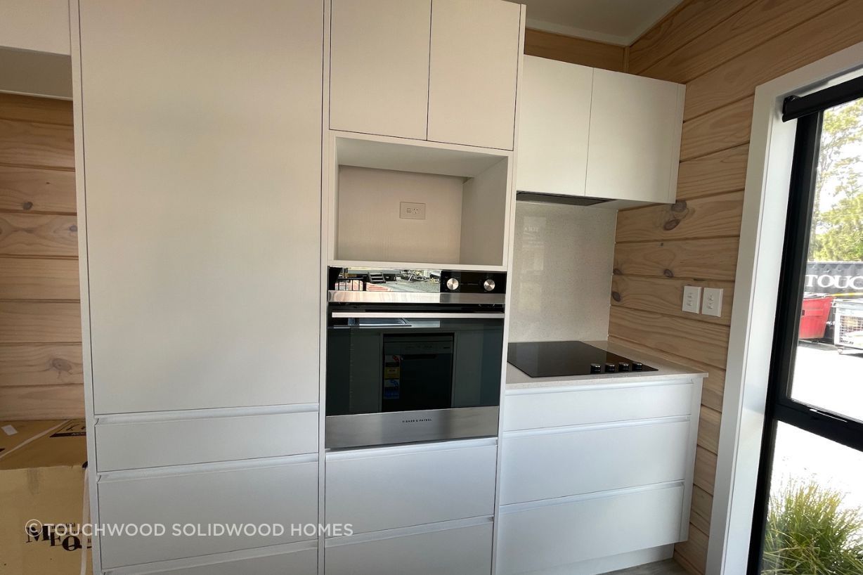 The Dreamwood 7 kitchen features a wall oven, pantry, and full-length window