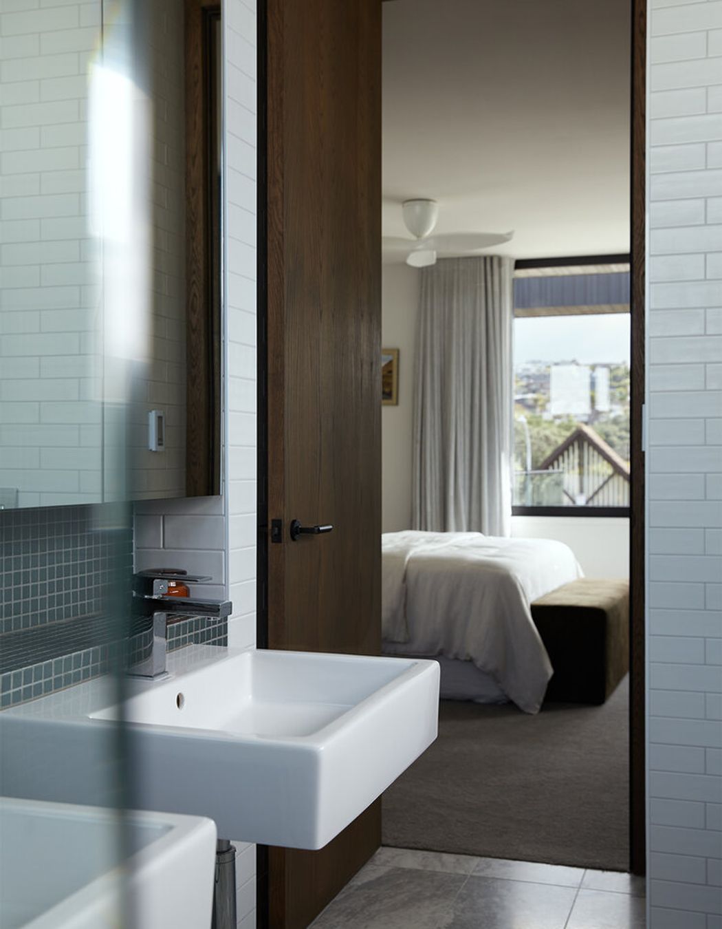 The master en suite features classic marble floor tiles and wall tiles in ocean-hues.