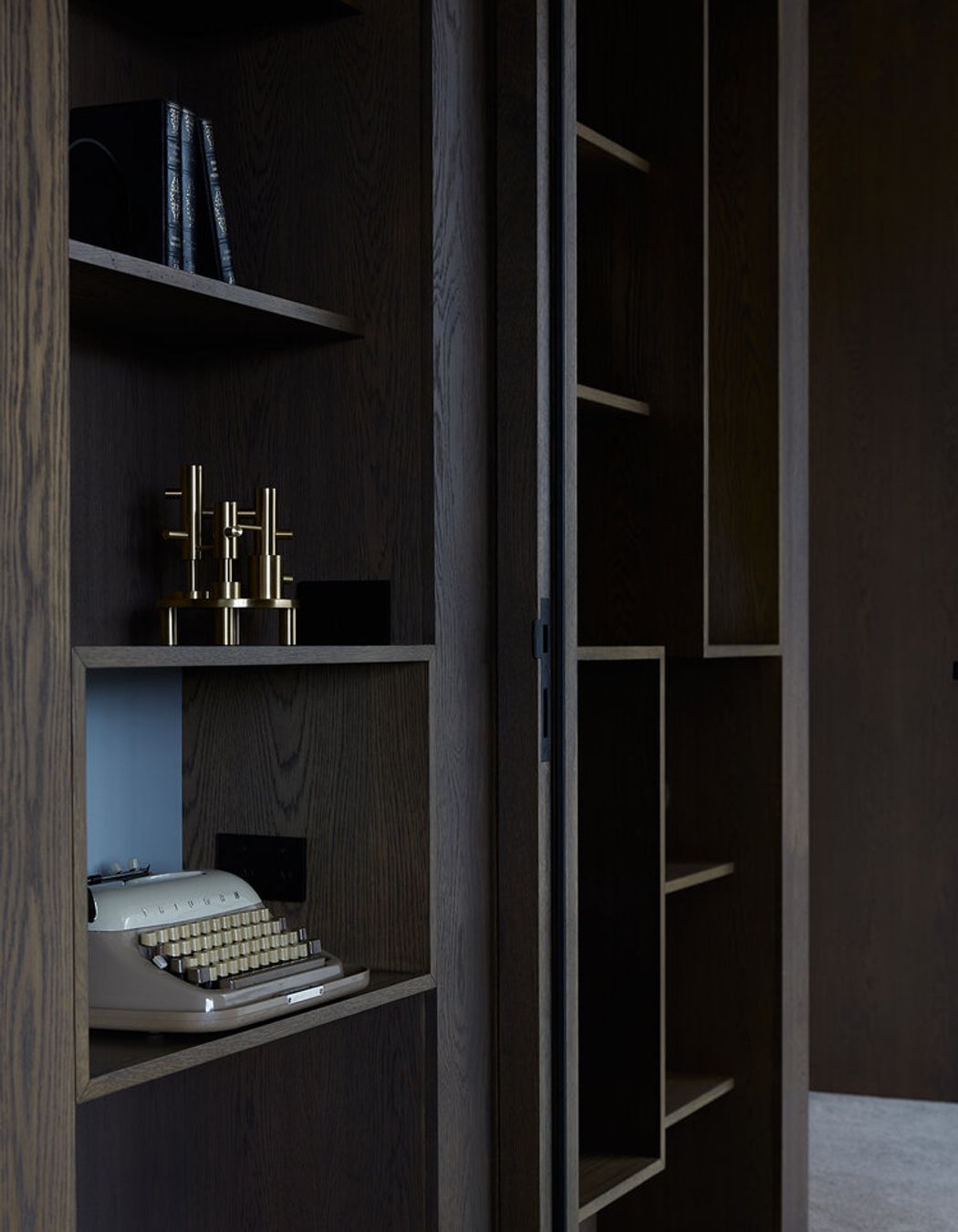 Built-in display cabinetry with a dark, wood-grain laminate is a nod to the Modernists.