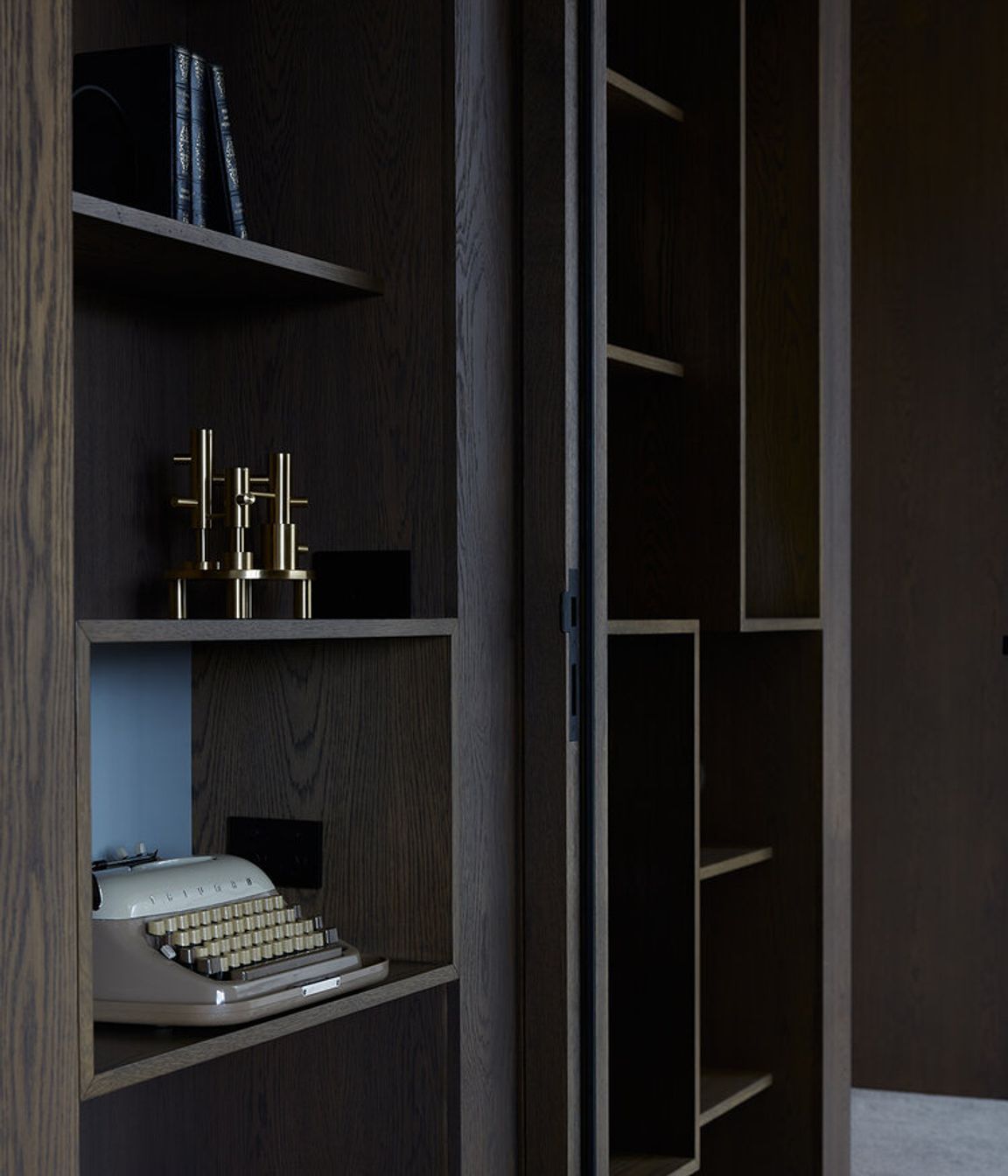 Built-in display cabinetry with a dark, wood-grain laminate is a nod to the Modernists.