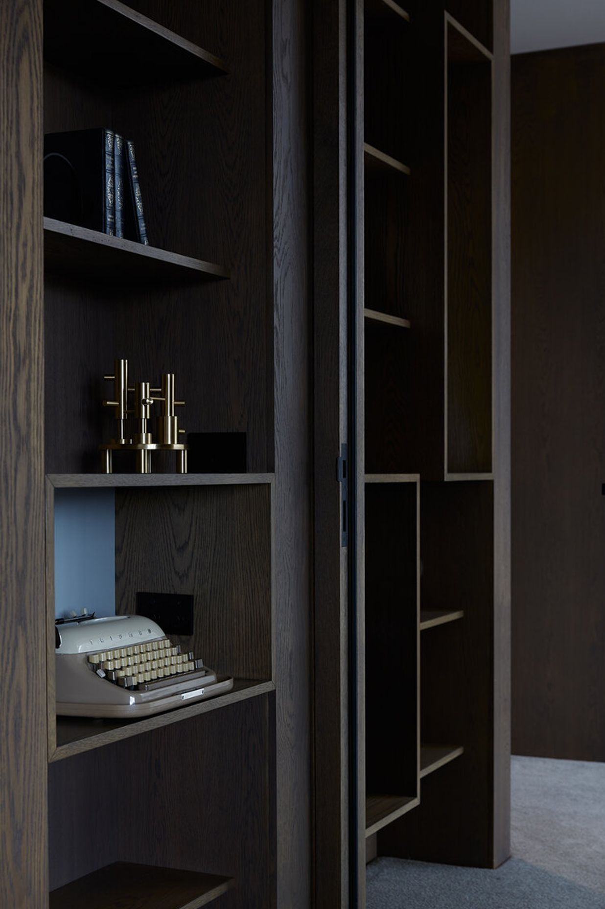 Built-in display cabinetry with a dark, wood-grain laminate is a nod to the Modernists.