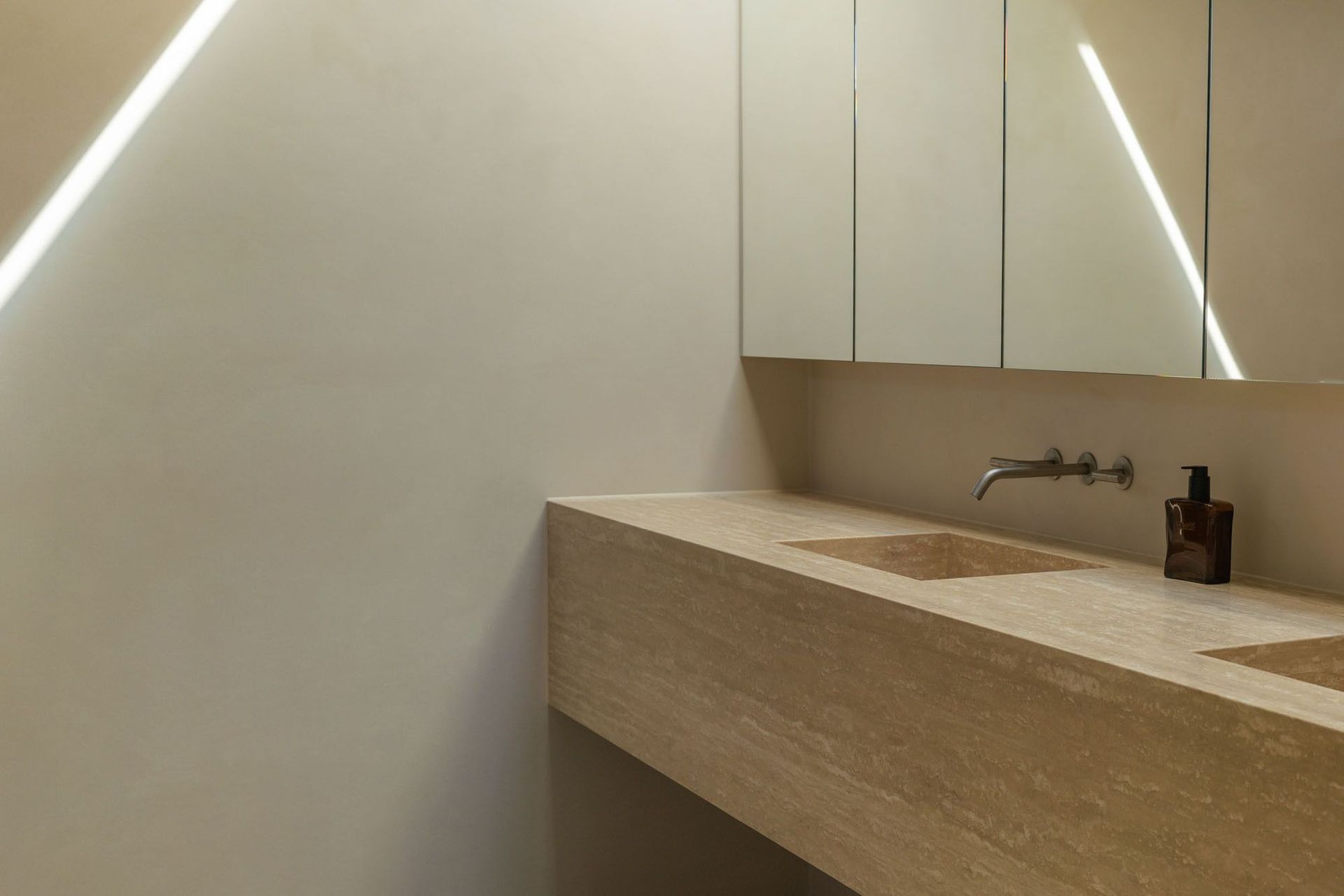 House on Pacific - Bathroom. Ensuite vanity with a travertine top and mirrored cabinets.