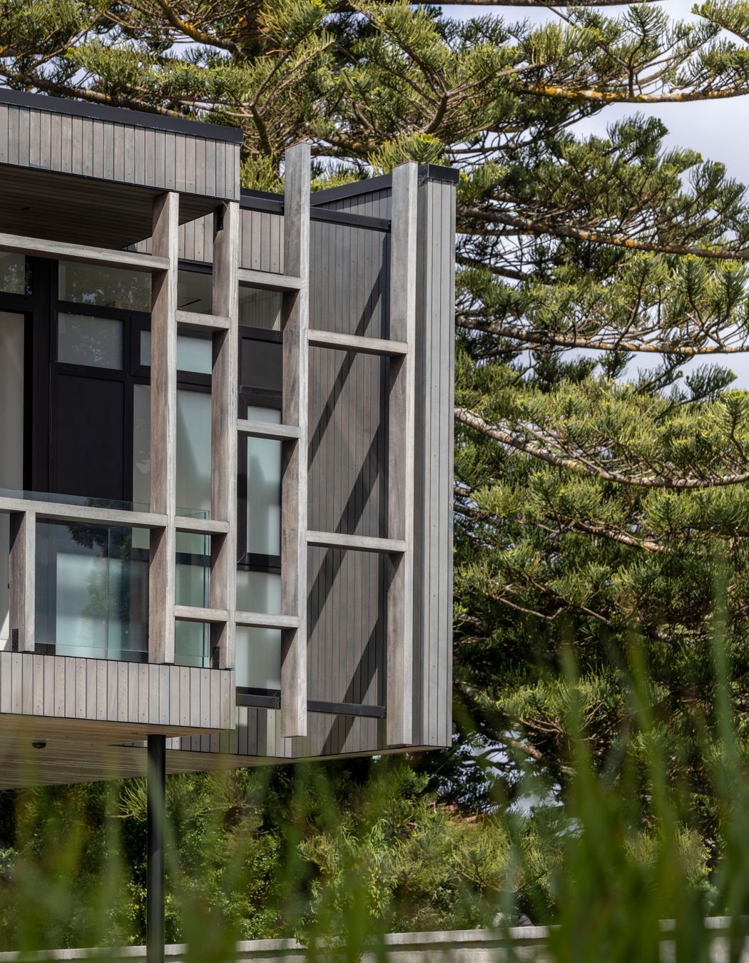 The exterior material palette references the subdued tones of the beach.
