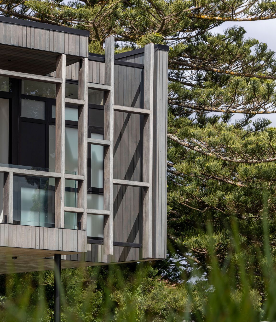 The exterior material palette references the subdued tones of the beach.