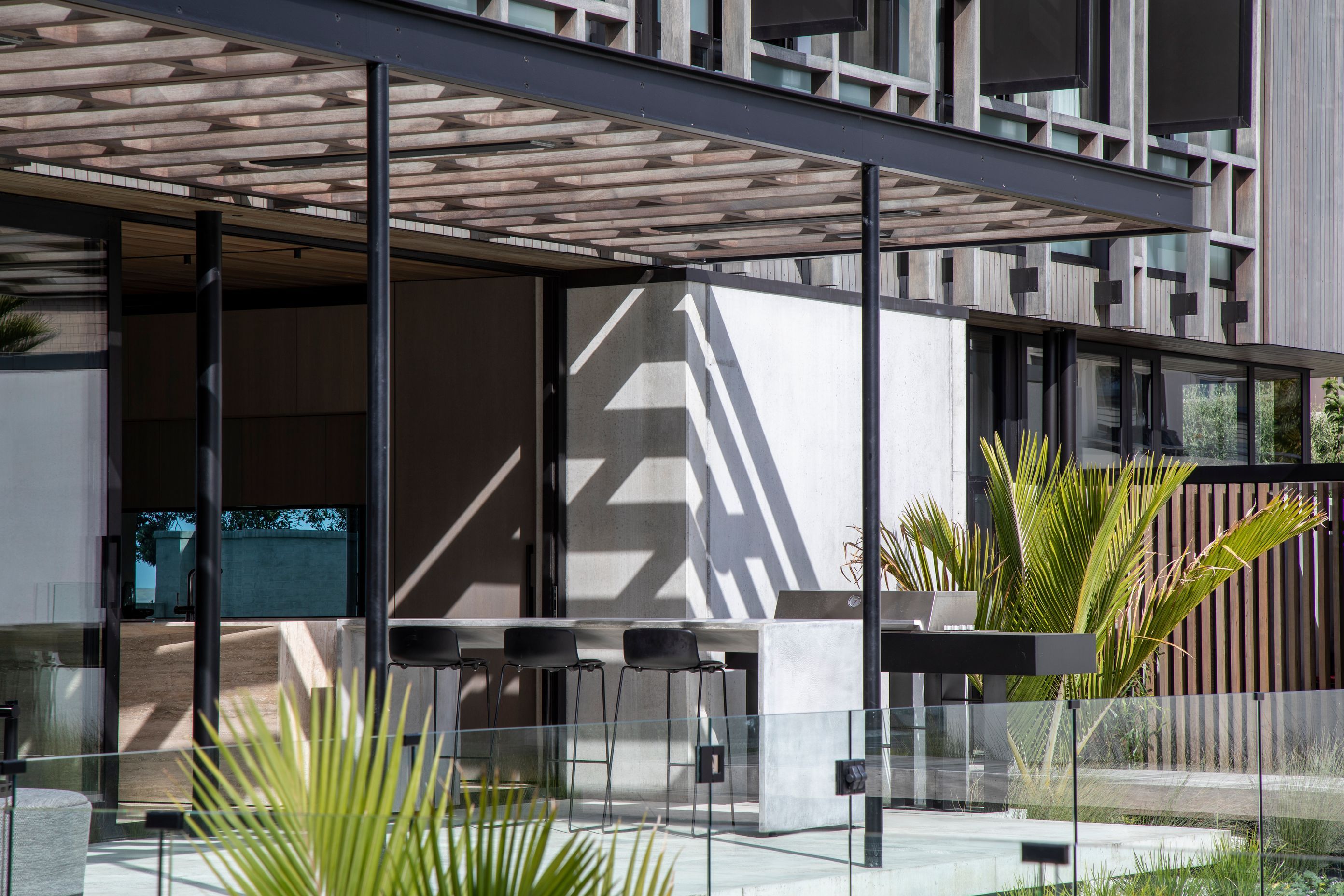 Through floor-to-ceiling sliders, the outdoor area can be directly accessed from the kitchen and living spaces.