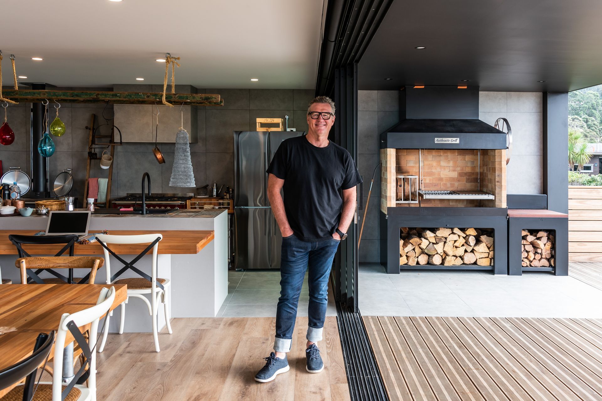 Seamless indoor-outdoor flow. Tracks Ash 600x600mm on Kitchen and BBQ are floors and walls. Neptune Max Natural Oak on the interior floor.