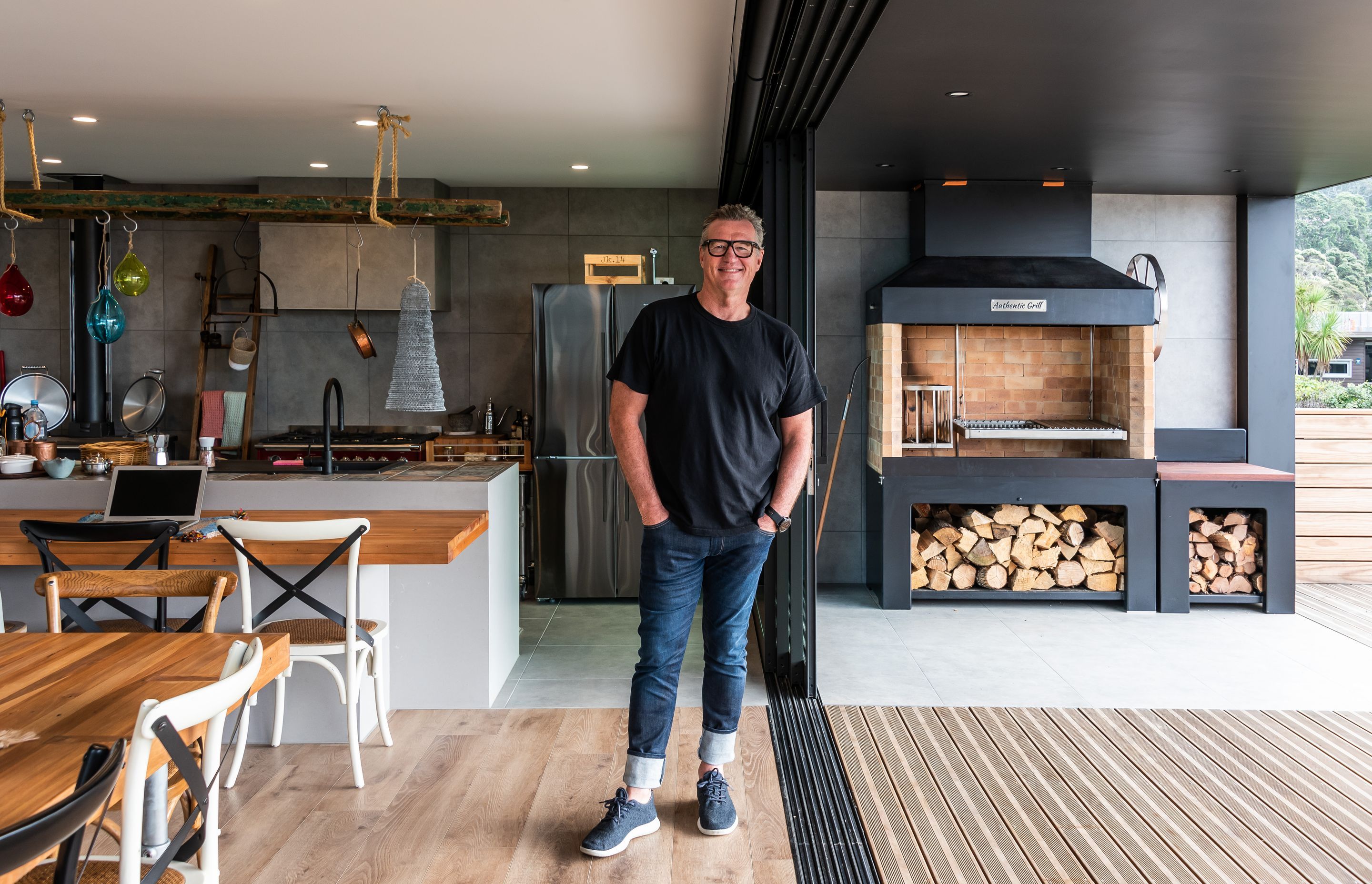 Seamless indoor-outdoor flow. Tracks Ash 600x600mm on Kitchen and BBQ are floors and walls. Neptune Max Natural Oak on the interior floor.