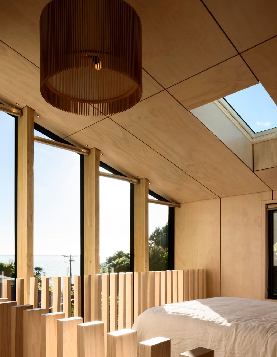 The northeast end of the building is glazed to form a double-height, full-width window that admits light into the living space and main bedroom and which is punctuated with LVL columns that serve to channel views towards the bay.