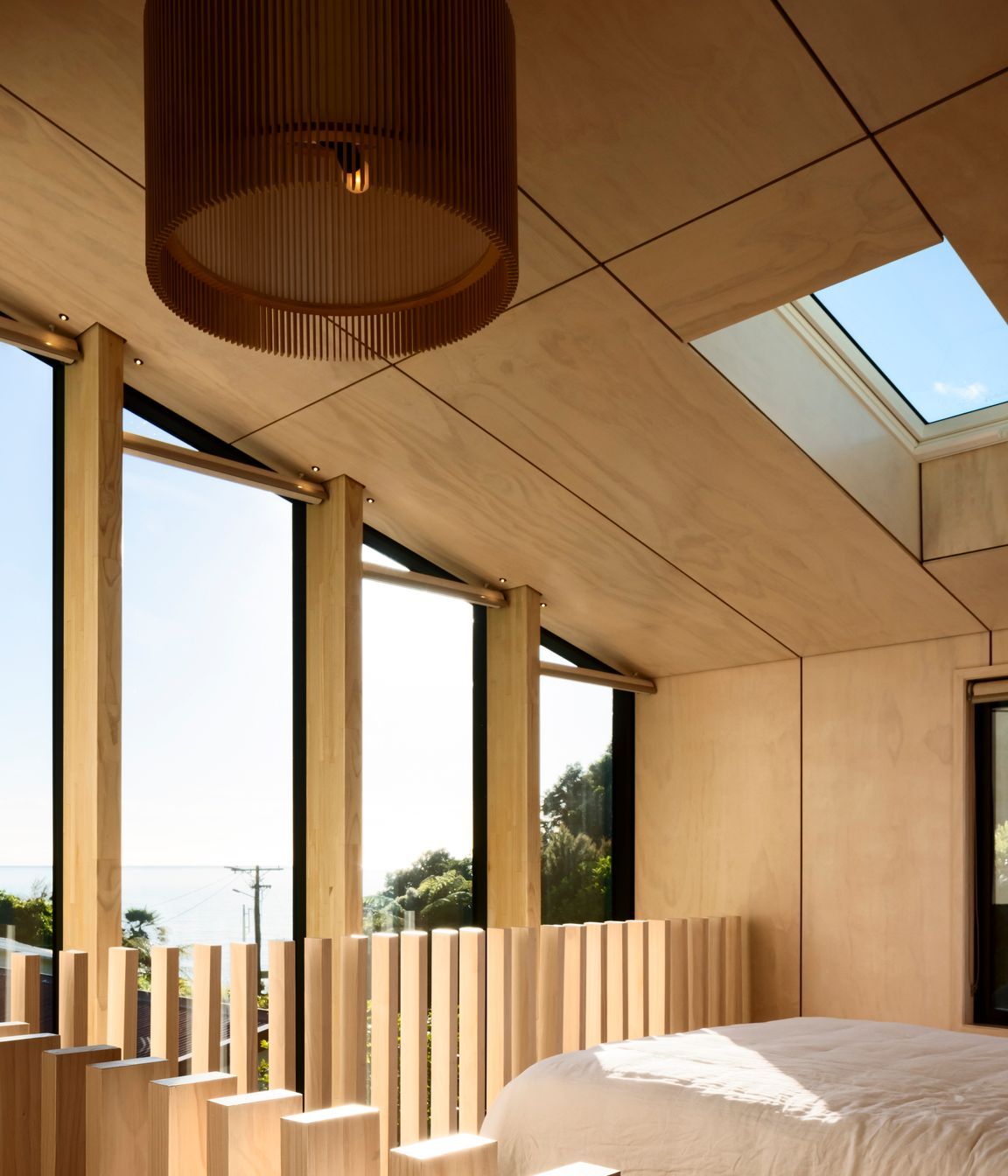 The northeast end of the building is glazed to form a double-height, full-width window that admits light into the living space and main bedroom and which is punctuated with LVL columns that serve to channel views towards the bay.