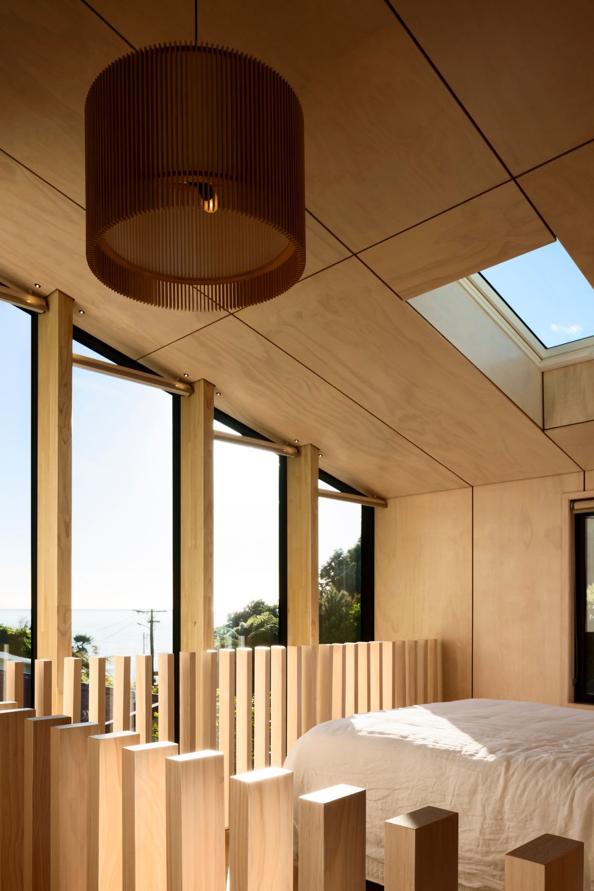The northeast end of the building is glazed to form a double-height, full-width window that admits light into the living space and main bedroom and which is punctuated with LVL columns that serve to channel views towards the bay.