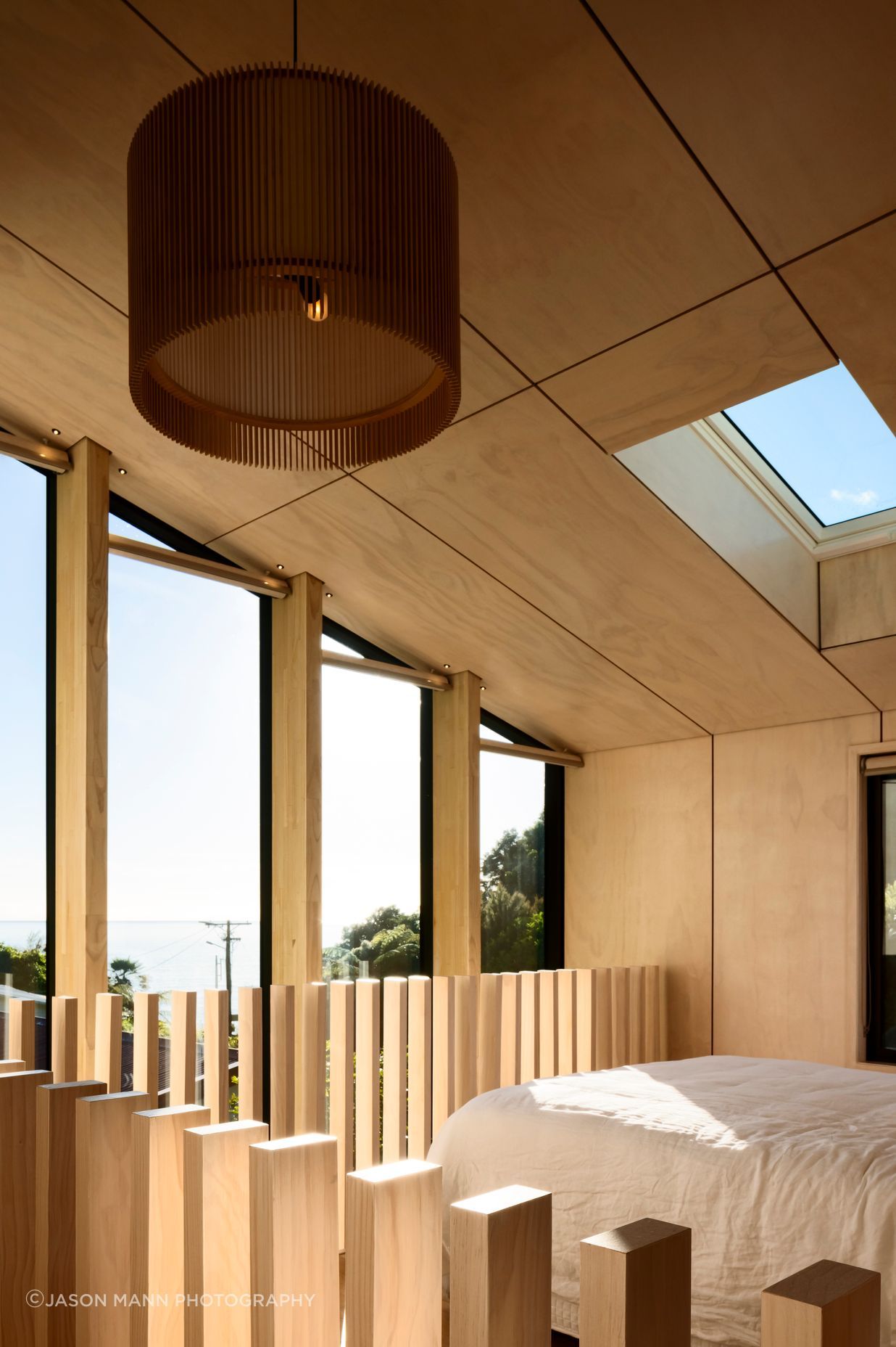 The northeast end of the building is glazed to form a double-height, full-width window that admits light into the living space and main bedroom and which is punctuated with LVL columns that serve to channel views towards the bay.