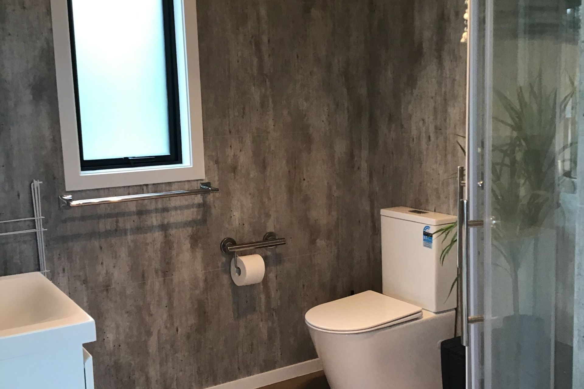 Generous sized bathroom with grab rails to toilet and shower. Space for washing machine also