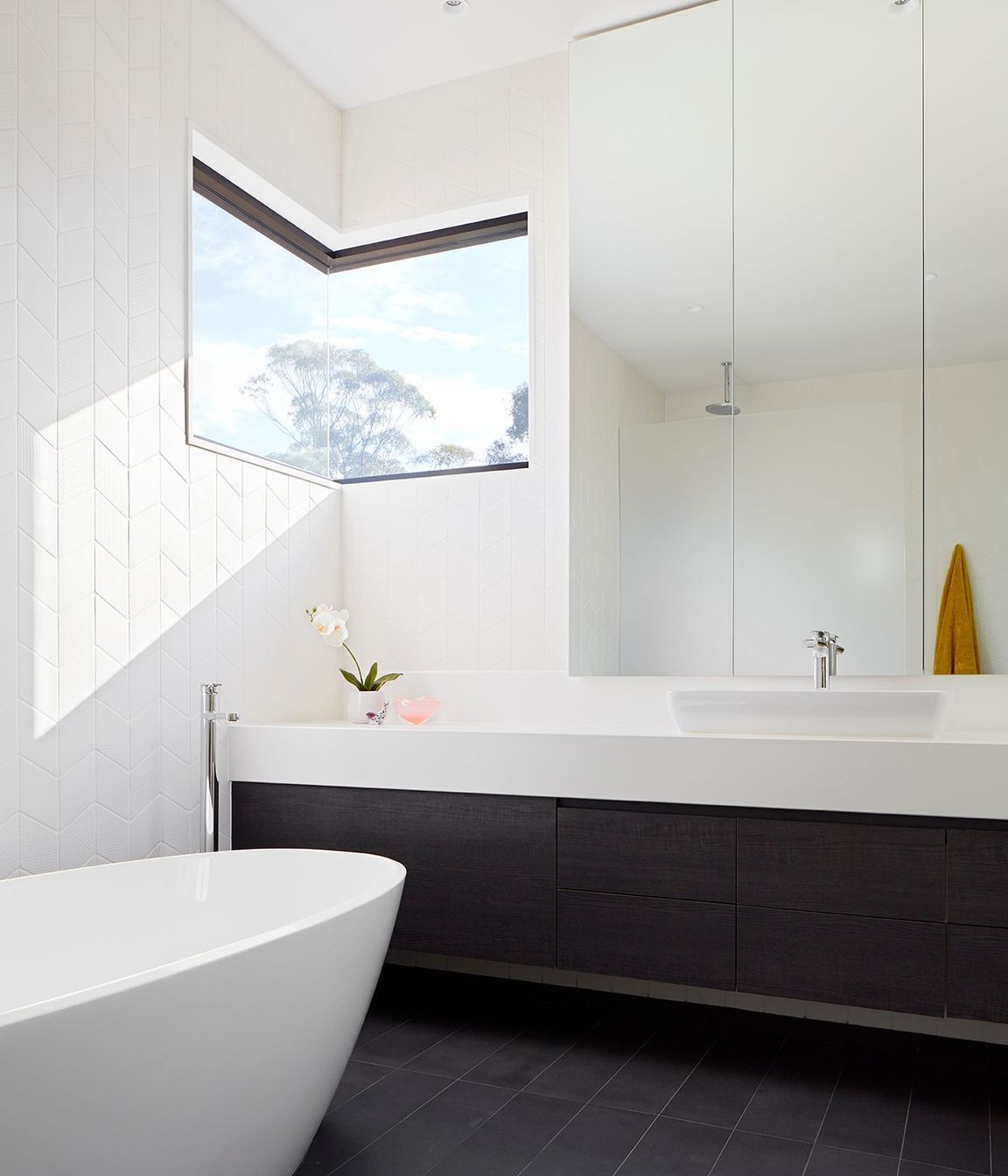 The Ensuite takes advantage of tree top views, and like the Powder Room utilizes soft, textured wall tiles and minimal white fittings.