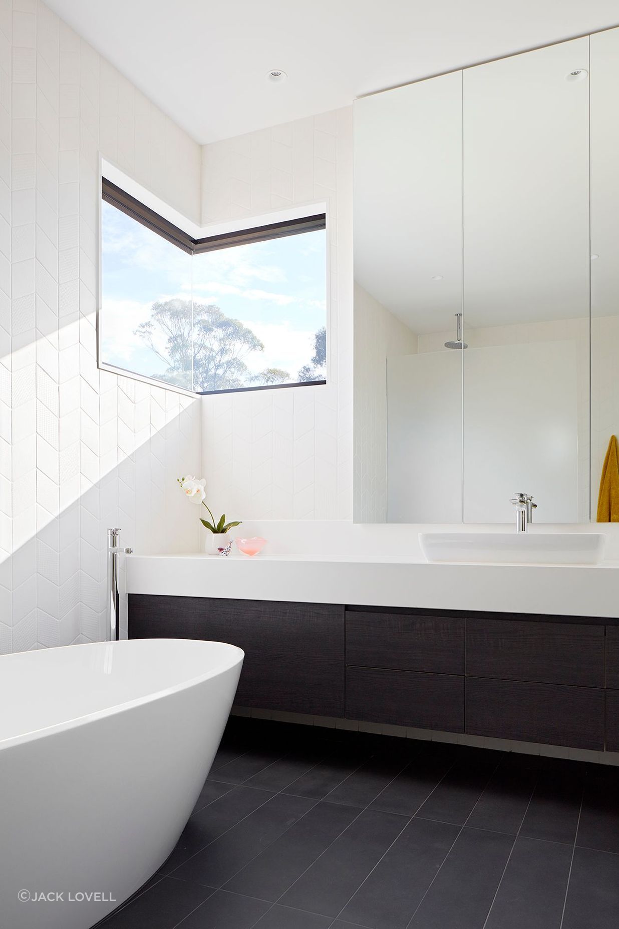 The Ensuite takes advantage of tree top views, and like the Powder Room utilizes soft, textured wall tiles and minimal white fittings.
