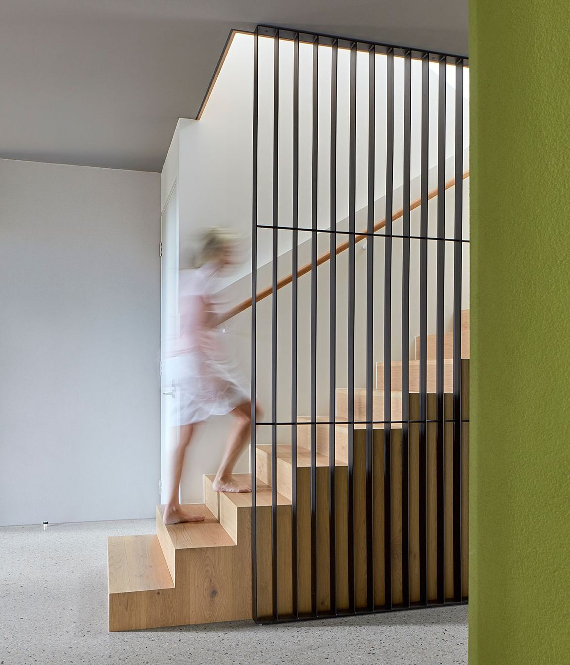 The interior scheme of the ground floor reflects the formal materiality – solid, grounded concrete terraces and rendered block balanced with polished-concrete screed floors and charcoal coloured ceilings. This broodiness is punctuated by the organic shape of the green rendered cellar – a shot of colour repeated throughout the house.