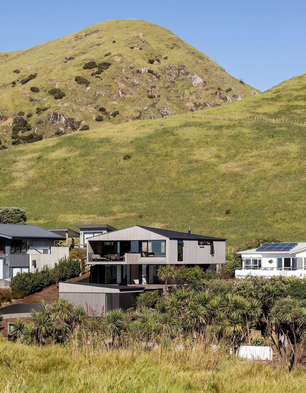 The bach is neatly slotted in the middle of a small row of houses facing the sea.