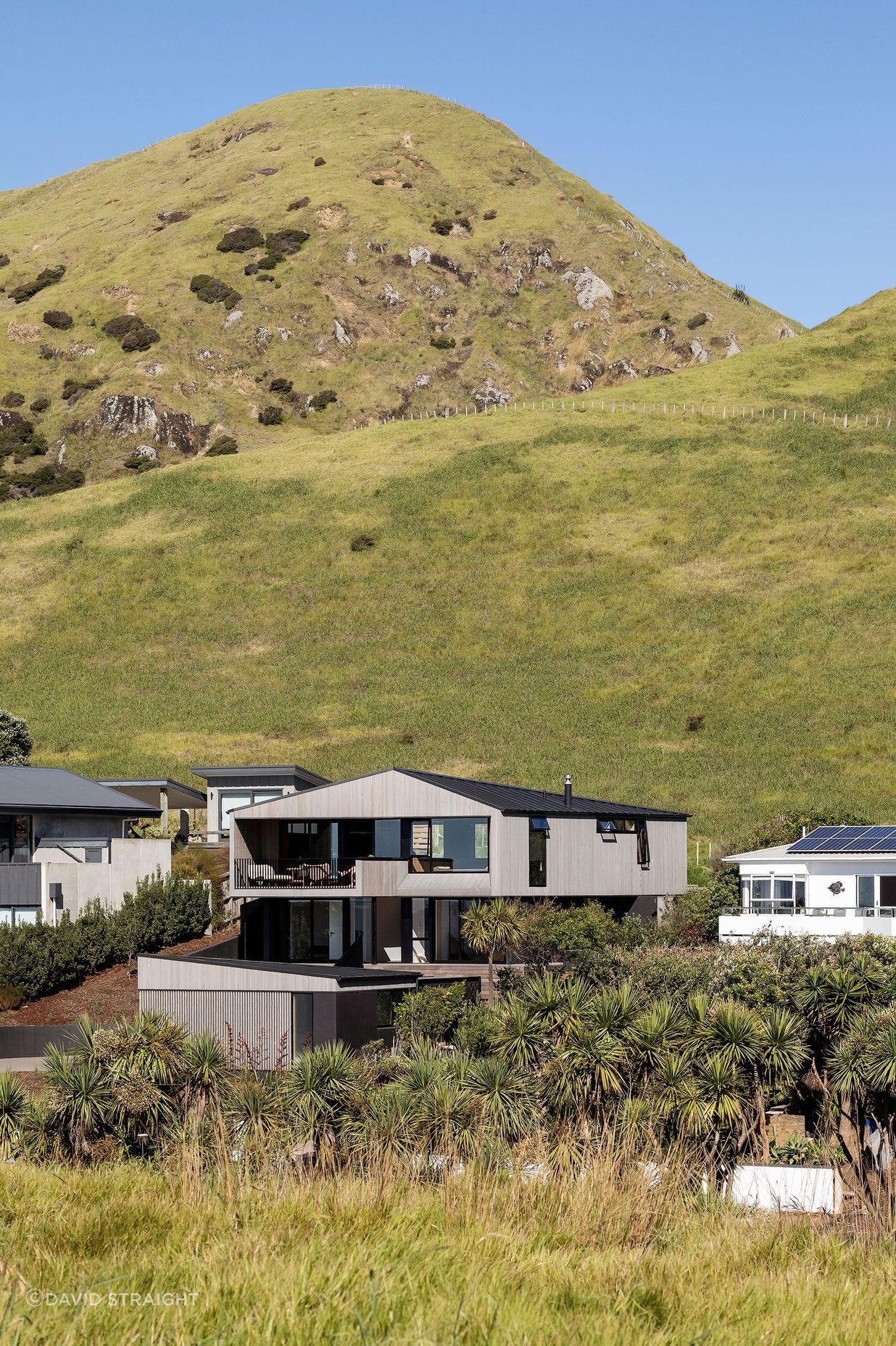 The bach is neatly slotted in the middle of a small row of houses facing the sea.