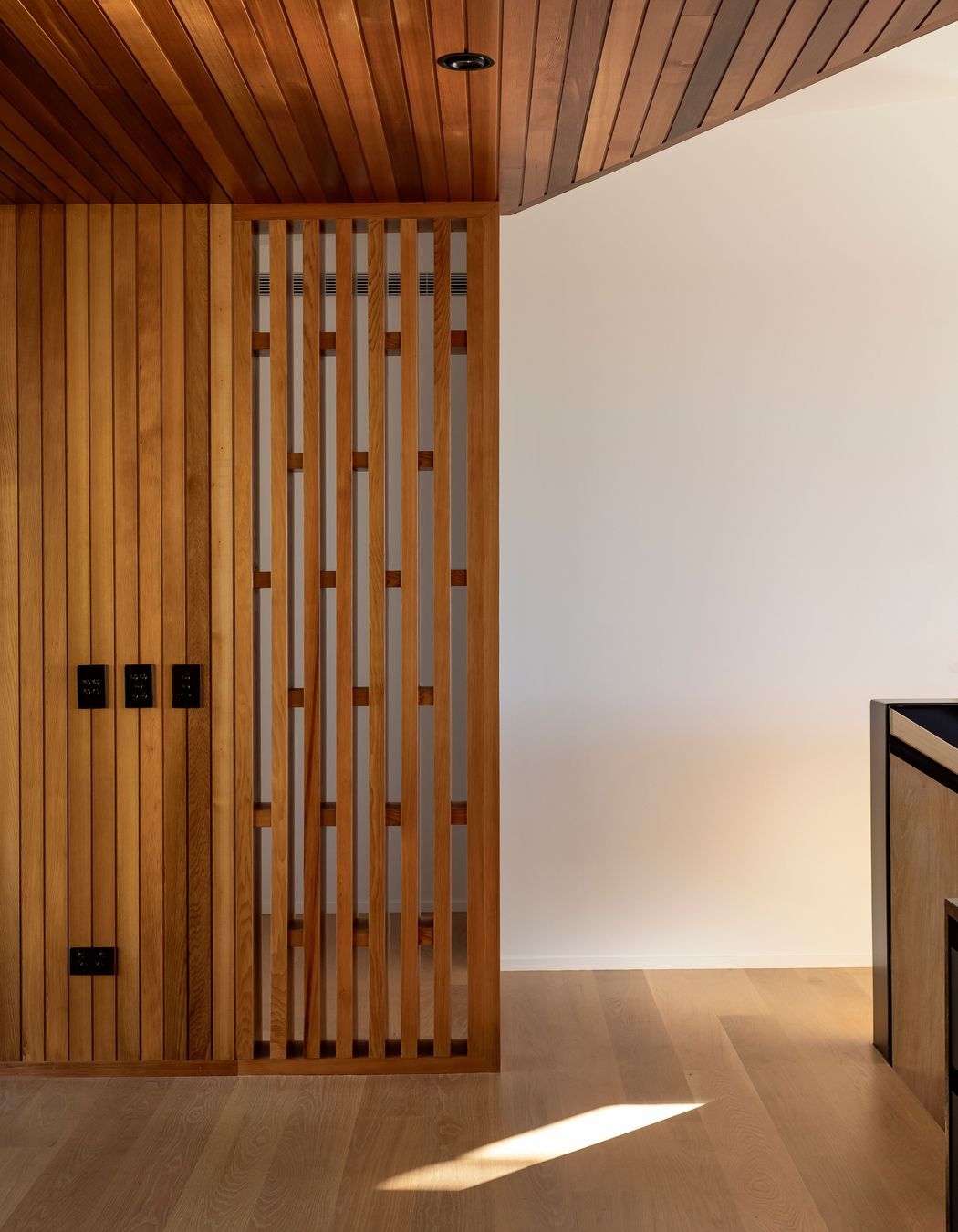 A timber screen provides privacy for the master suite, while allowing light in.