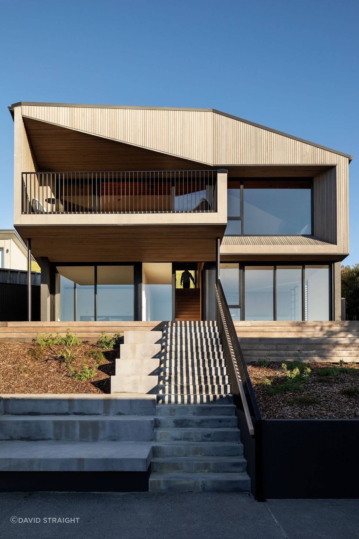 A central concrete stair leads up to the entry.