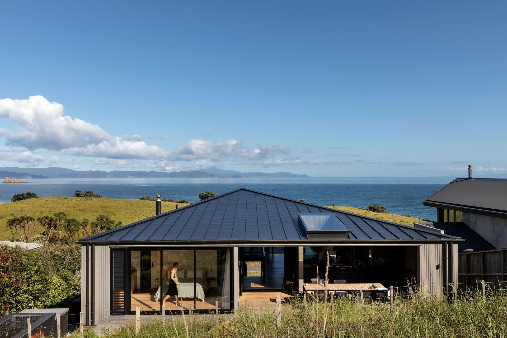 The home seen from the hillside behind; the master is on the left and the outdoor entertainment space on the right connects with the kitchen.