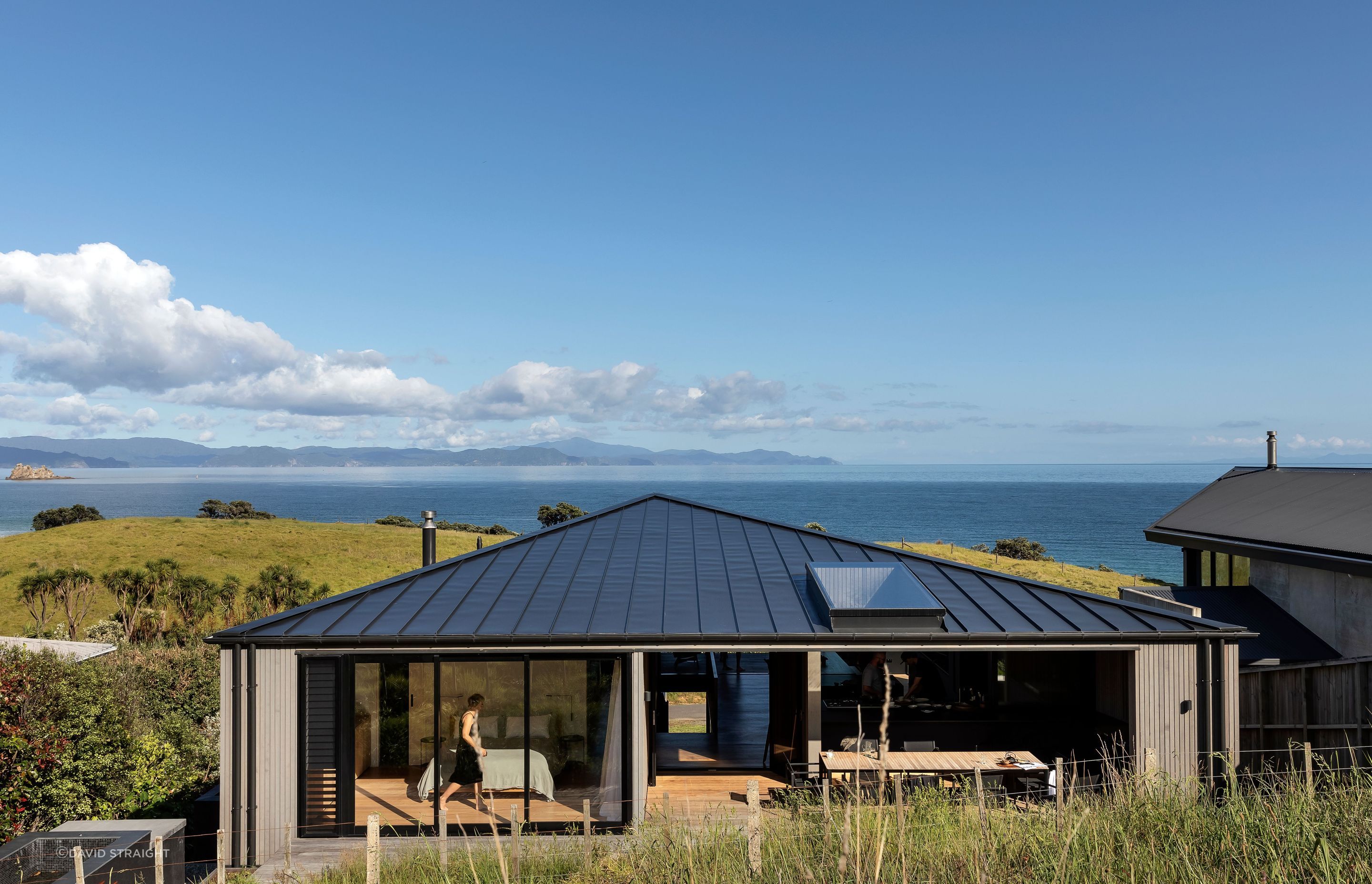 The home seen from the hillside behind; the master is on the left and the outdoor entertainment space on the right connects with the kitchen.