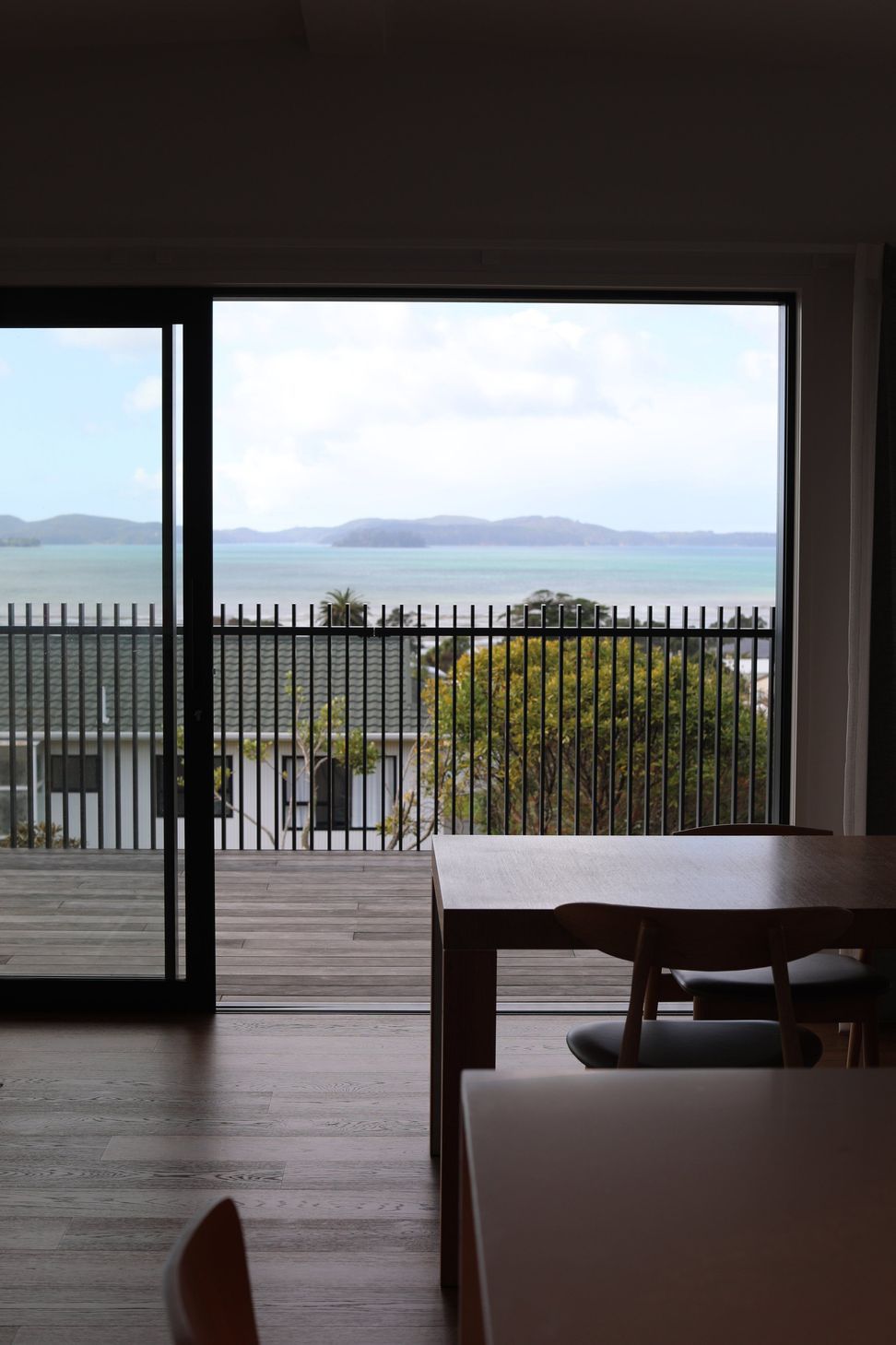 Snells Beach New-Build | Interior View - positioned with endless seaviews, custom steel railing, large stacking doors and hardwood floors.