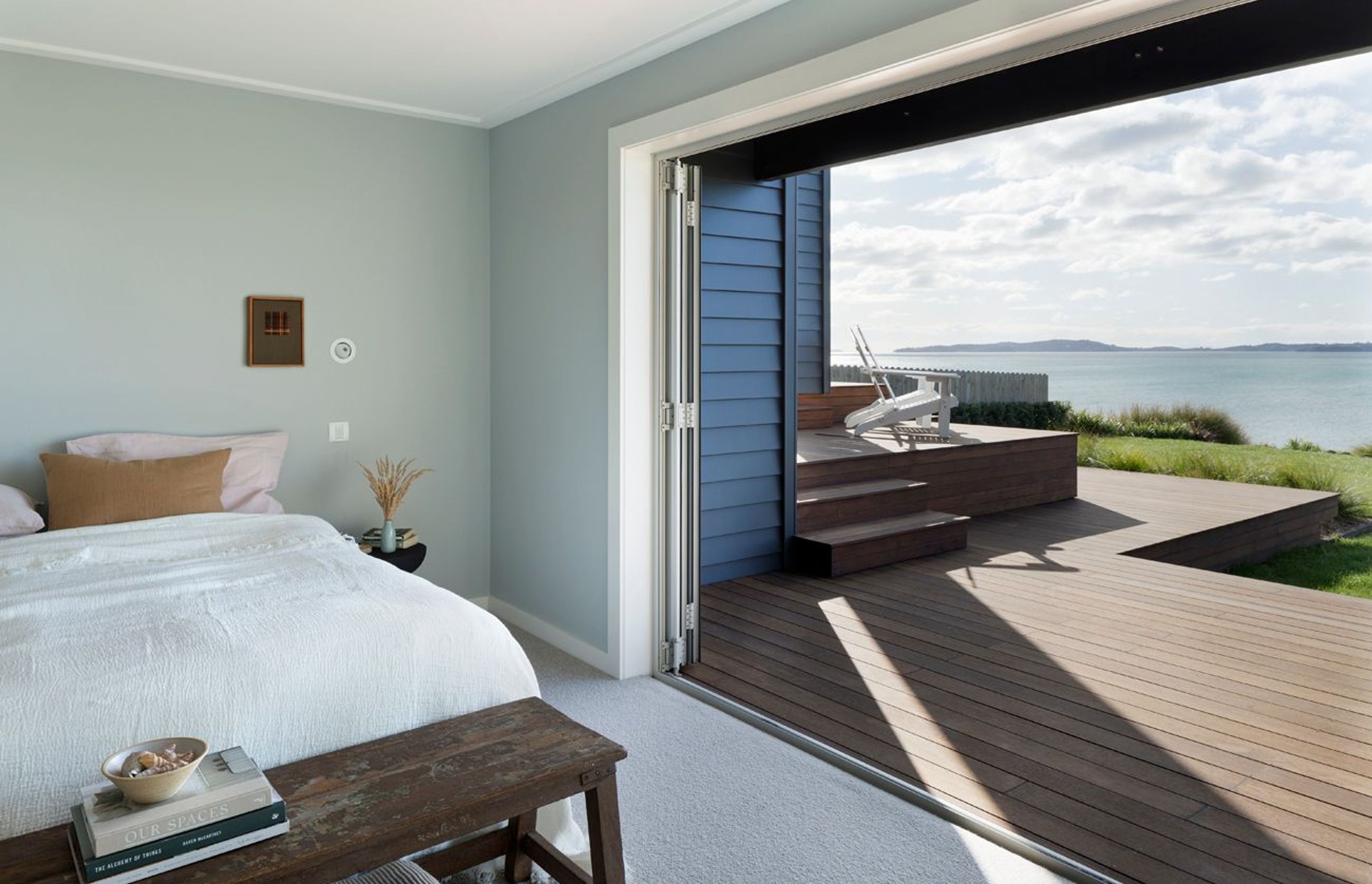 A bank of bifold doors provides seamless egress to the outdoors from this bedroom suite. An elevated viewing platform is the ideal spot to watch the world go by.