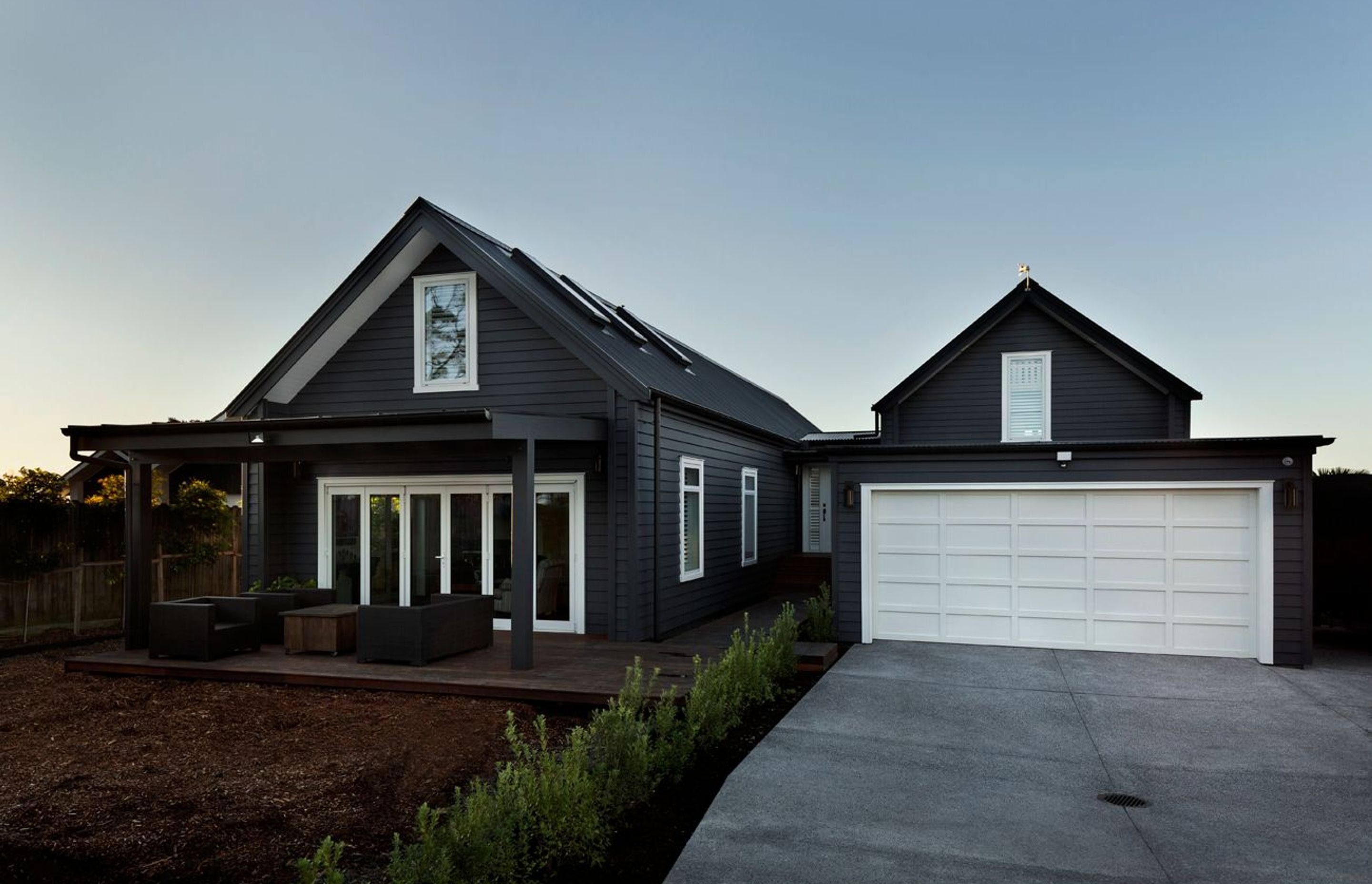 Gable forms and darkly painted weatherboards reference the bach that had previously stood on the site for more than 50 years.