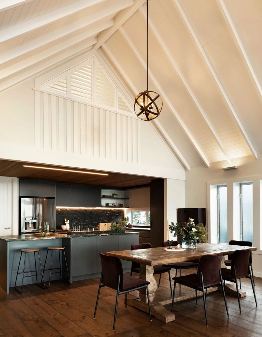 The darker palette of the kitchen, along with the lower ceiling height, allows it to recede into the space, once again directing people's attentions towards the views.
