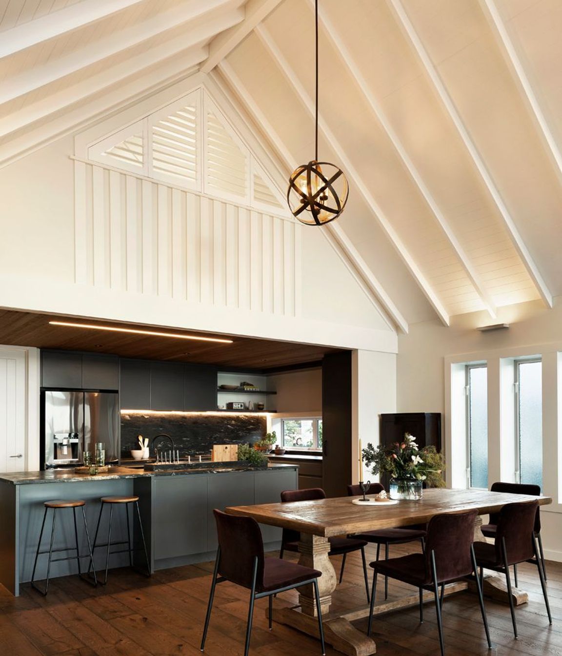 The darker palette of the kitchen, along with the lower ceiling height, allows it to recede into the space, once again directing people's attentions towards the views.