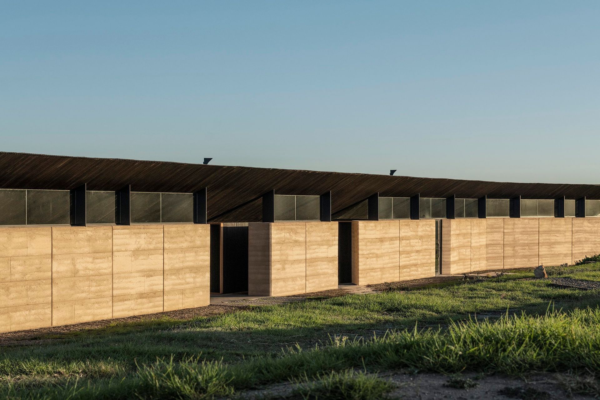 Nature's embrace meets architectural elegance at Mystery Bay House. Discover the captivating beauty of rammed earth walls, seamlessly integrating sustainable design with coastal living