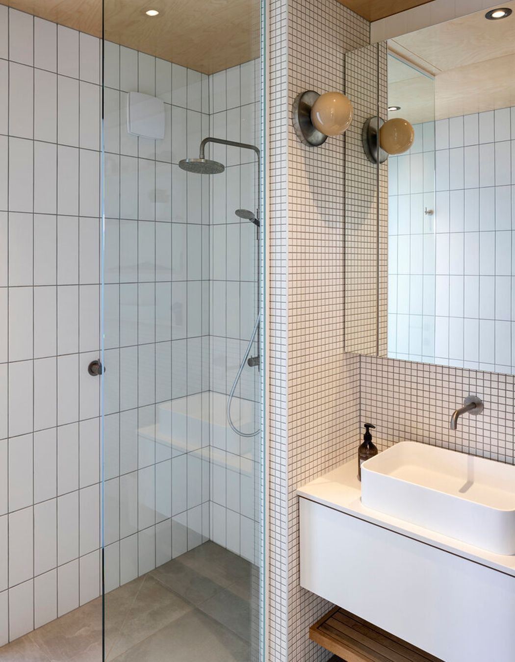 The ensuite bathroom continues the pared back materiality of the interior design.