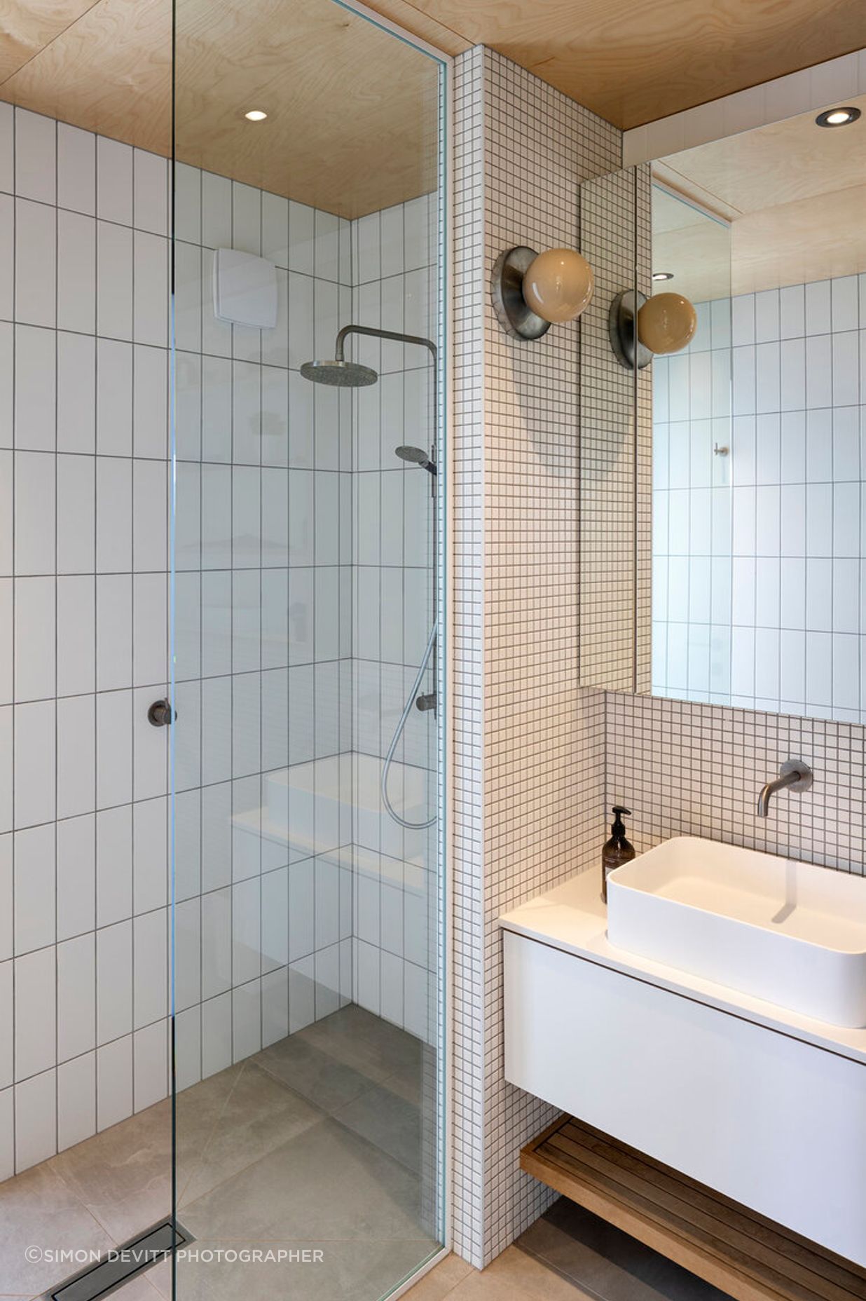 The ensuite bathroom continues the pared back materiality of the interior design.