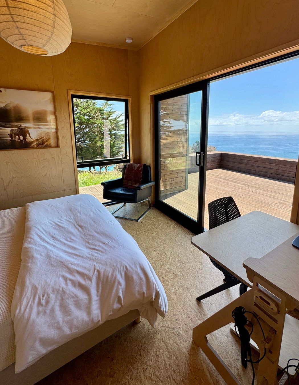 Guest bedroom with birch walls and OSB satin flooring