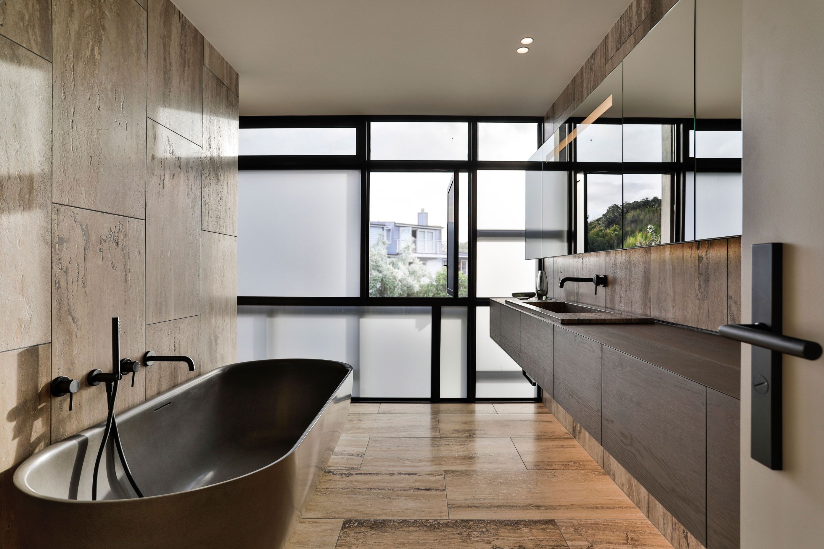 The grid patterns of the exterior joinery are combined with frosted glass for privacy.