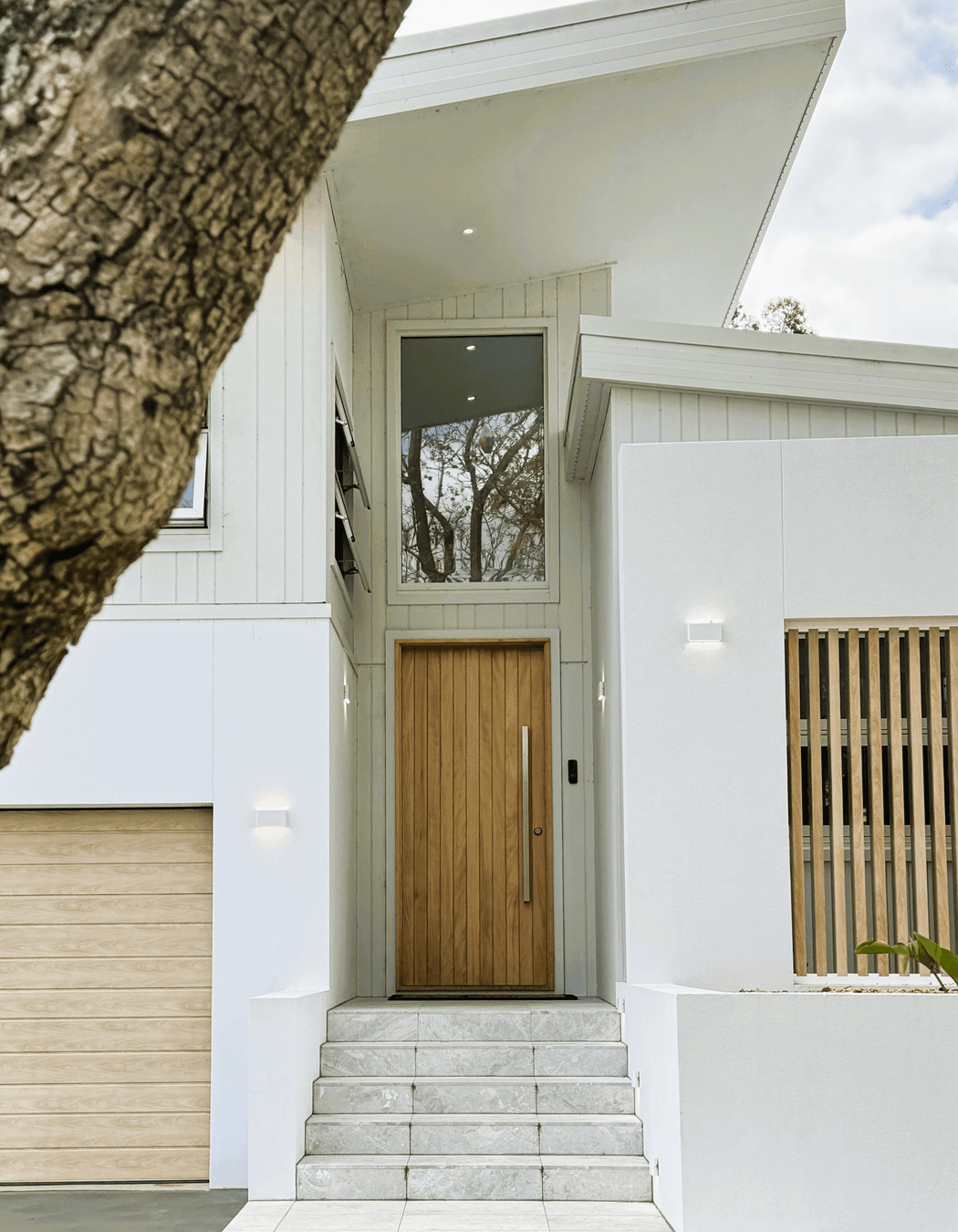 The timber garage door, front door and feature timber batten wall complement each other.