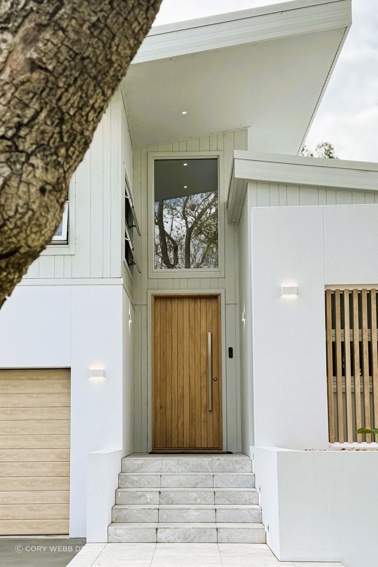 The timber garage door, front door and feature timber batten wall complement each other.