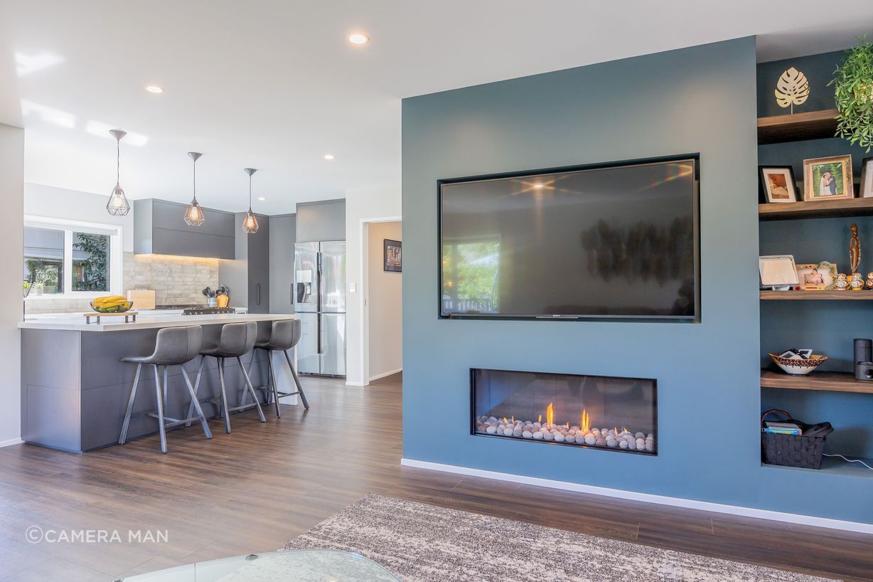 Resene Alabaster to ceiling, architraves & skirting; Resene Triple White Pointer to walls apart from feature wall; Resene Balderdash to feature fireplace wall; Moduleo Transform Falcon Wood 28890 to floor; Large Oblong Pastel Stripe Cut Velvet Cushion