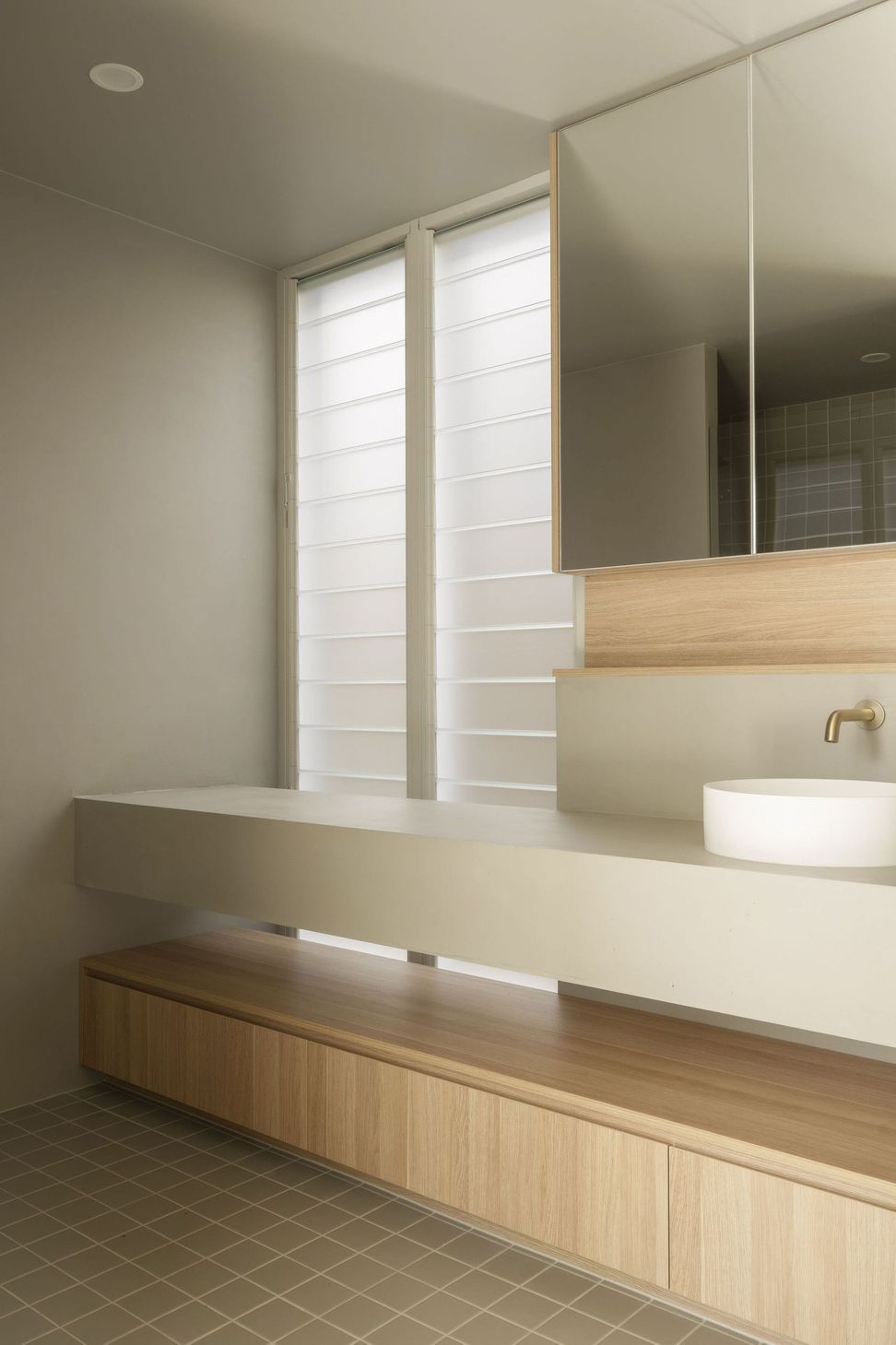 Gilbert Residence - Bathroom. Vessel basin with brass tapware beside a louvred window.