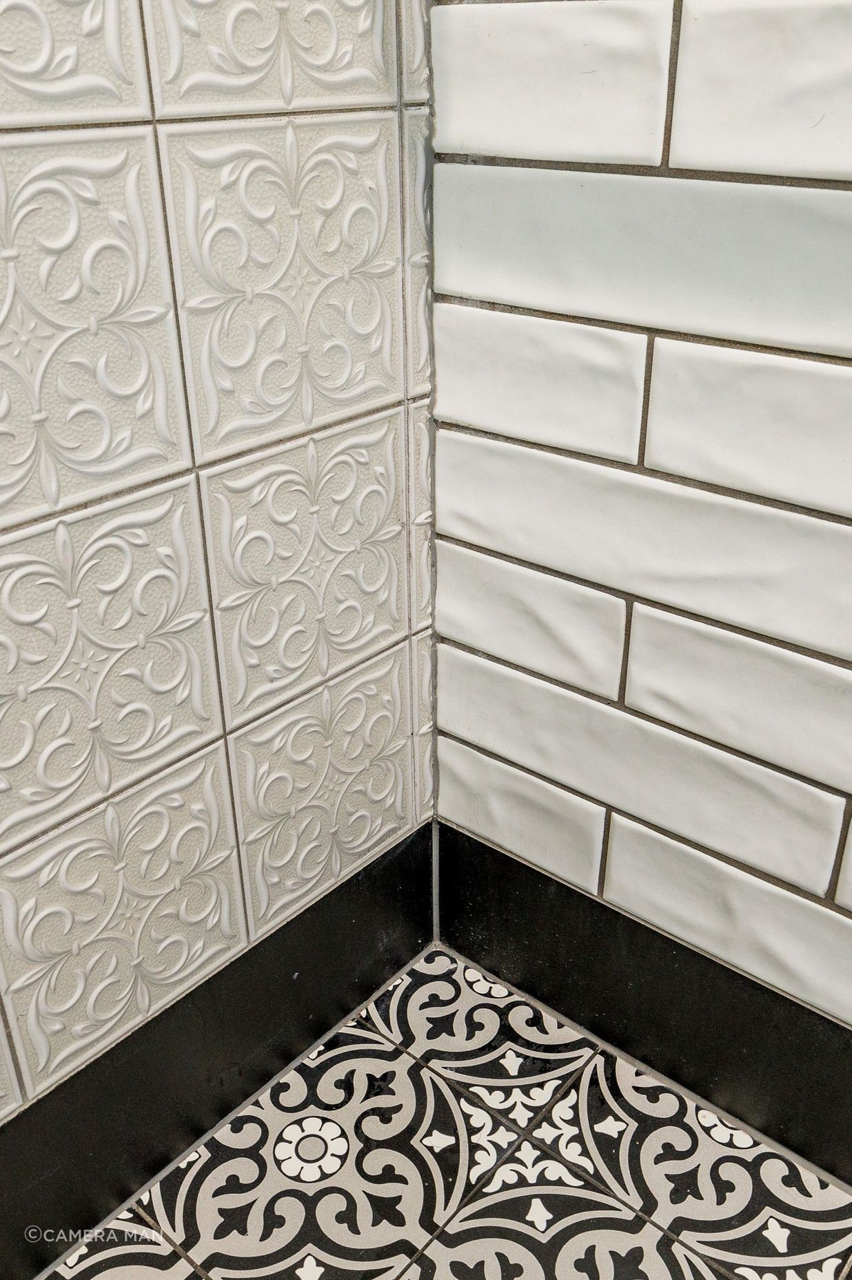 In this black & white bathroom the goal was to create a traditional charm. The floor tiles are Tile Warehouse - Element - Arabesque with the skirt tile Tile Warehouse -Pure Black Matt. The textured subway tiles are Tile Space - MT1366 - Marlow Cloud Gloss and the decorative antique embossed pattern tile is Tile Depot - Antigua Muse White.